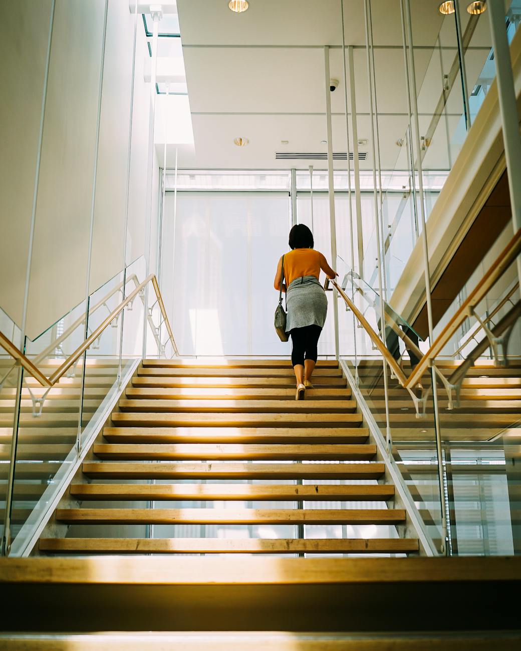 woman walking on brown stair Should you invest in a commercial property or rent?
