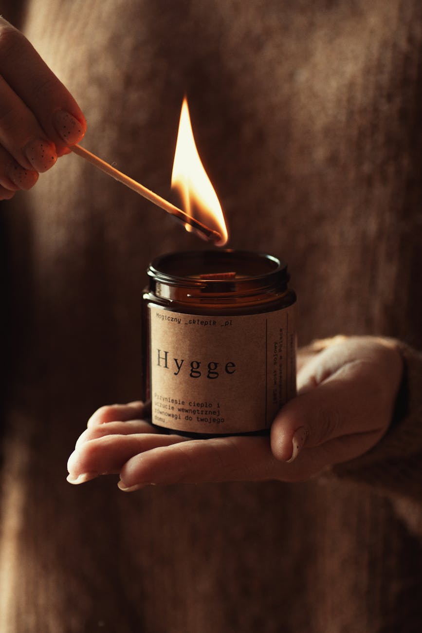 a person holding a candle with a flame hygge home design ideas to feed your mental health