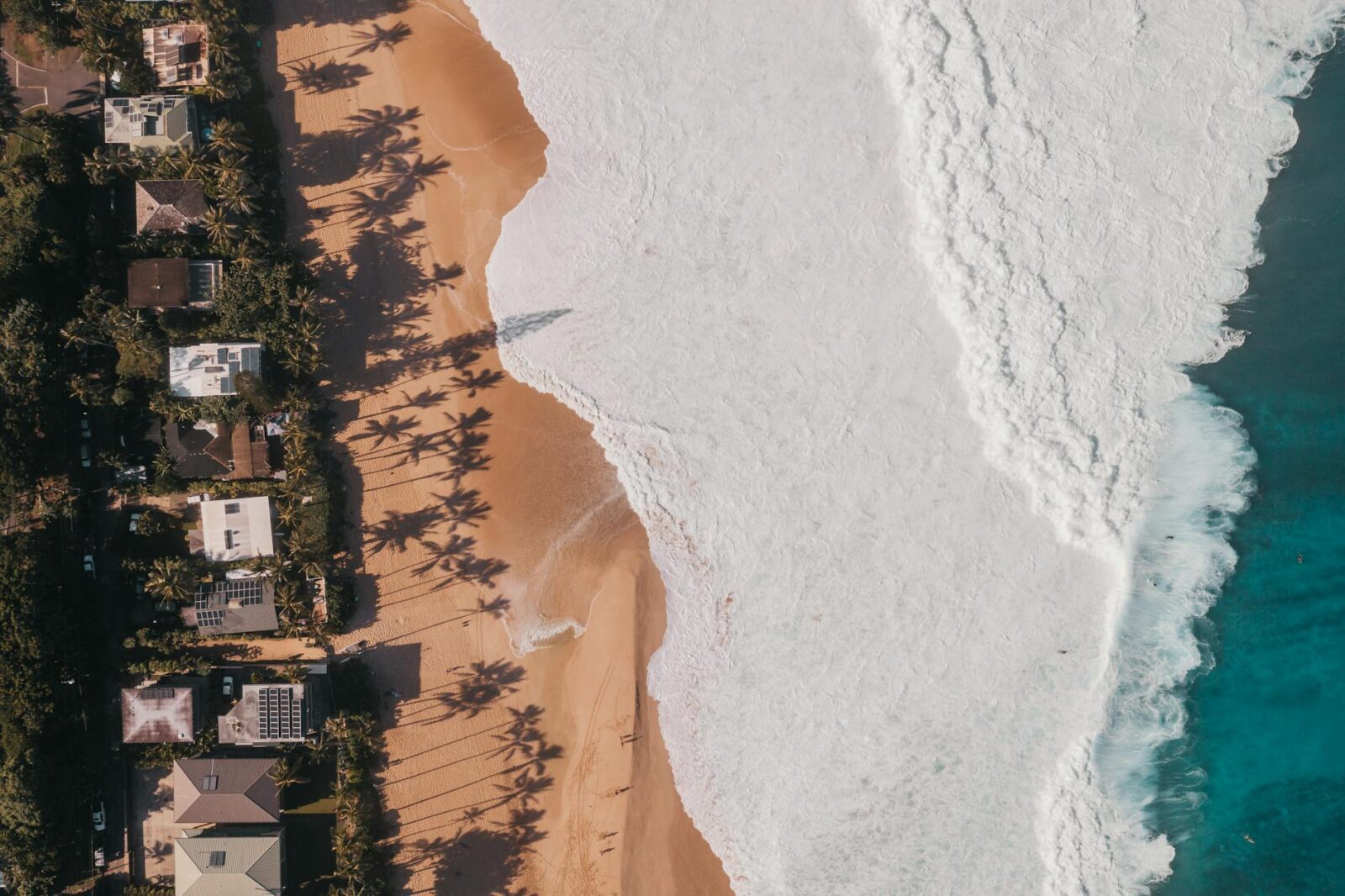 aerial photography of waves crashing to the sandy shore of a beach 10 Ways to Prep Your Vacation Rental Property for Guests