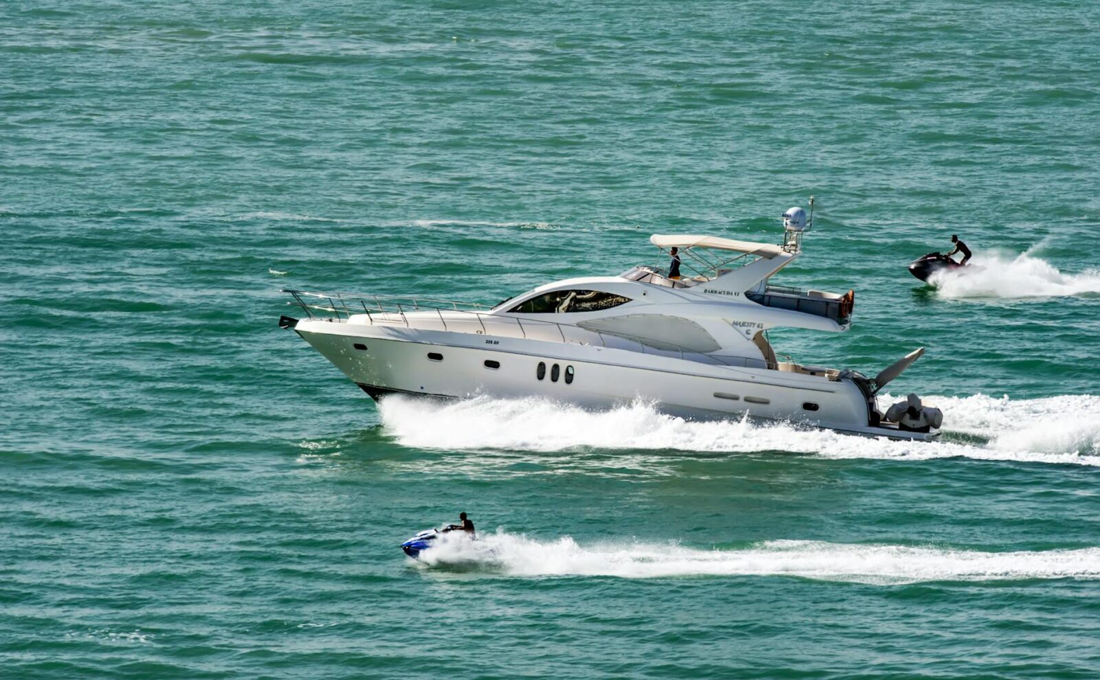 speedboat together with jetskis on body of water Life On The Water: One Of The Most Addictive Hobbies Out There