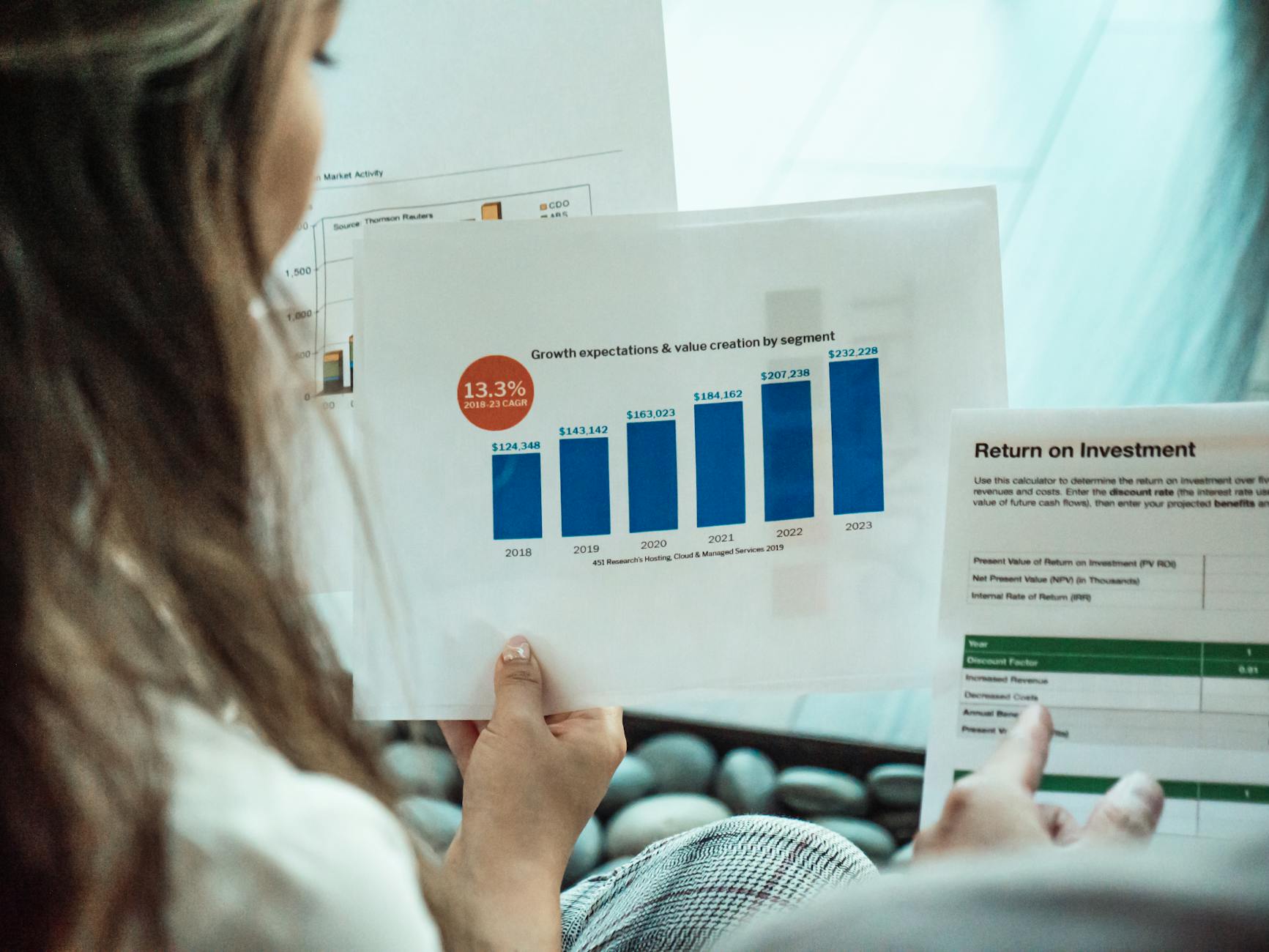 a person reading documents and reports 6 Real Estate Metrics All Pro Investors Track
