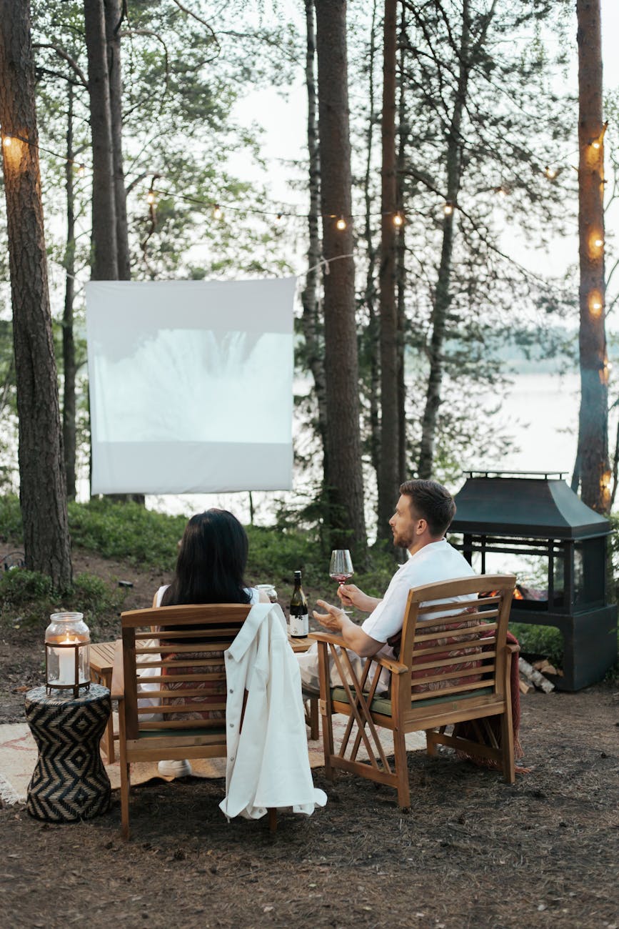 man and woman sitting on wooden chairs The Ultimate Guide to Indoor/Outdoor Living Spaces