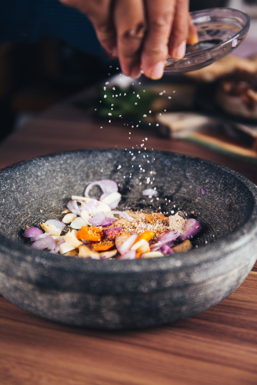 person pouring salt in bowl 4 Easy Ways to Build Flavor in Home Cooking (Without Overcomplicating Things)