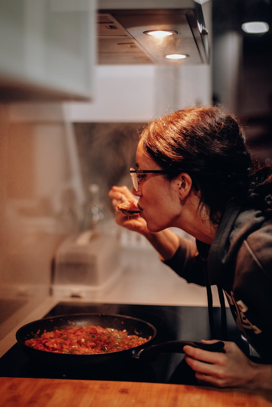 woman eating on cooking pan 4 Easy Ways to Build Flavor in Home Cooking (Without Overcomplicating Things)