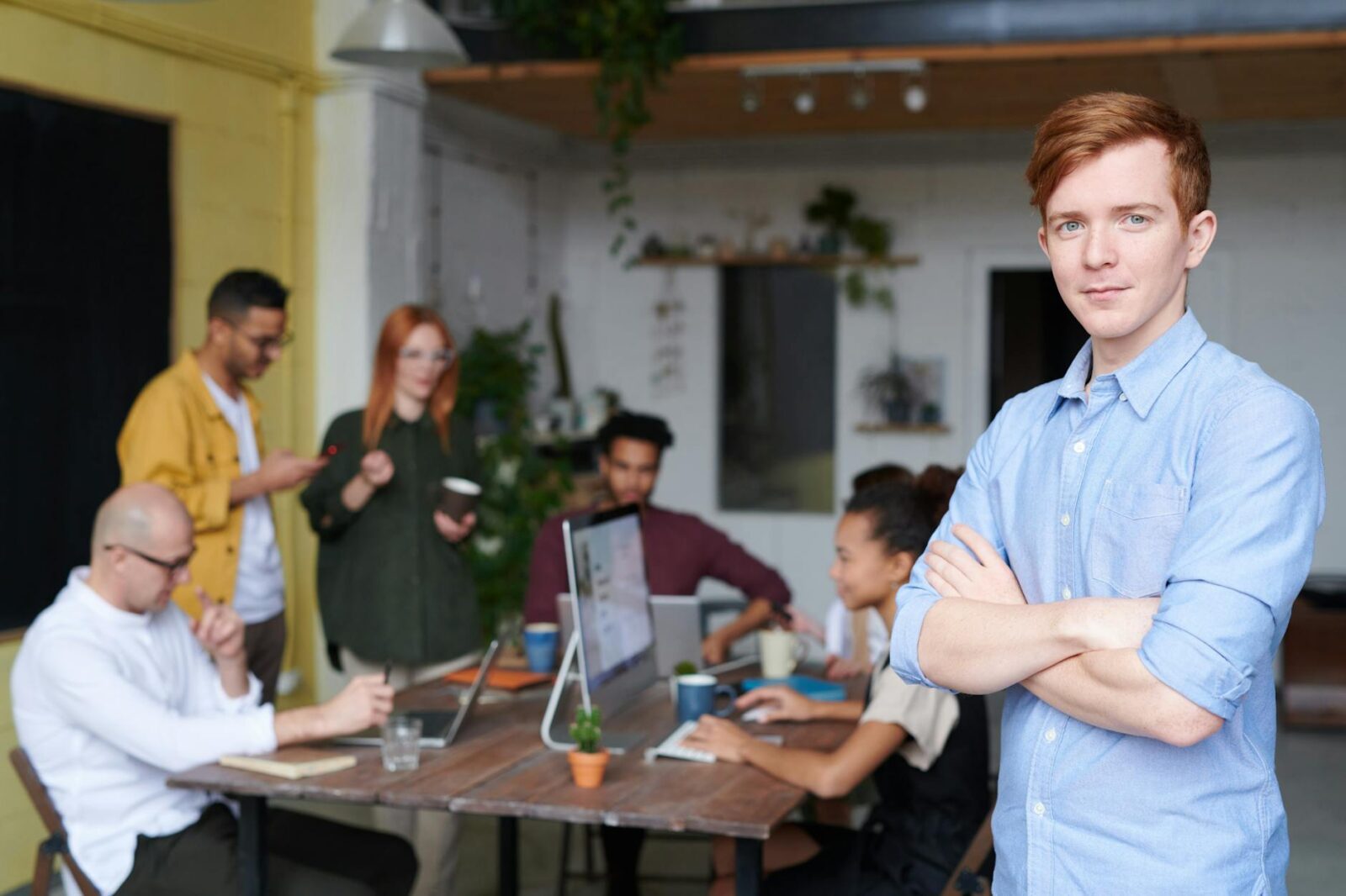 man standing beside people sitting beside table with laptops How to Invest in Your Business