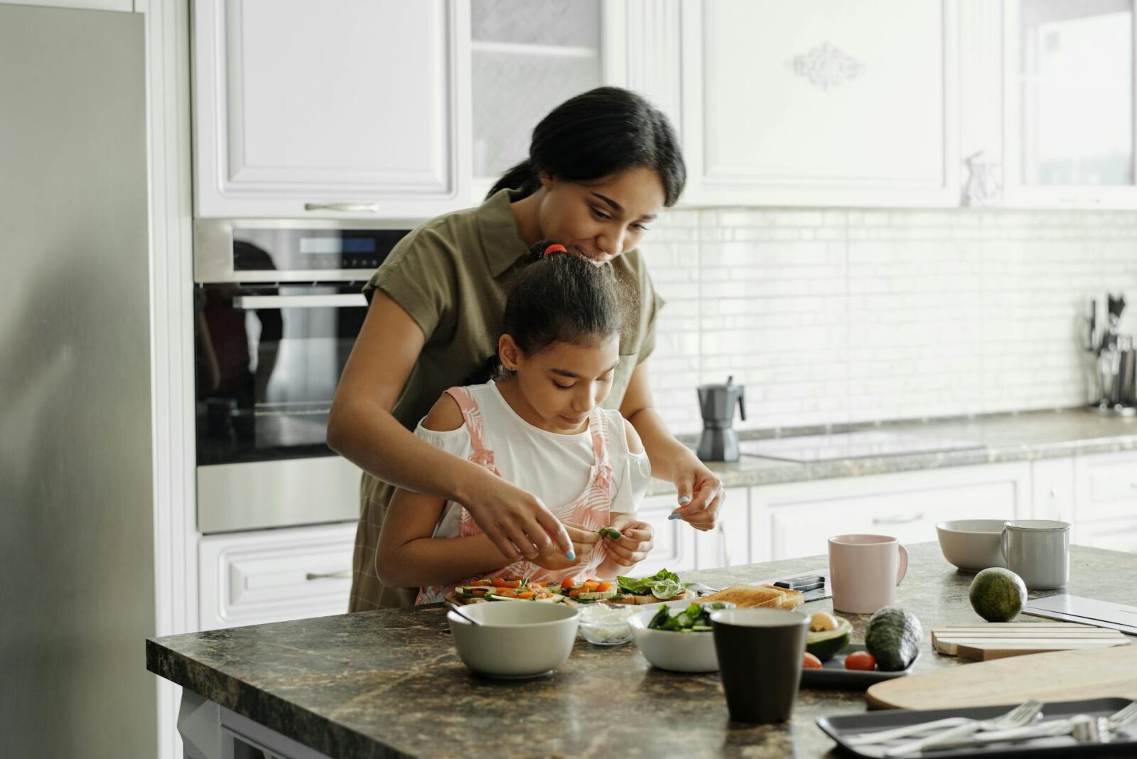 mother and daughter preparing avocado toast 4 Easy Ways to Build Flavor in Home Cooking (Without Overcomplicating Things)