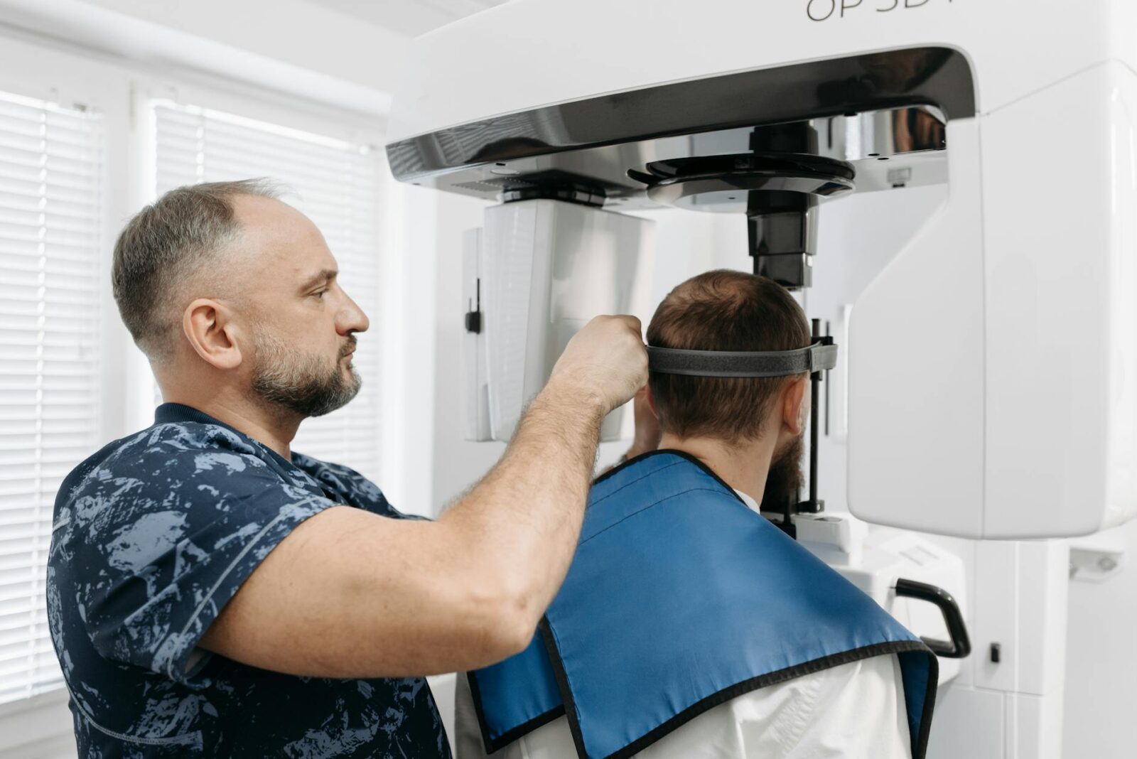 man preparing his patient for a dental x ray How to Modernize Your Dental Practice in 2025: Tech, Decor, & Marketing Tips