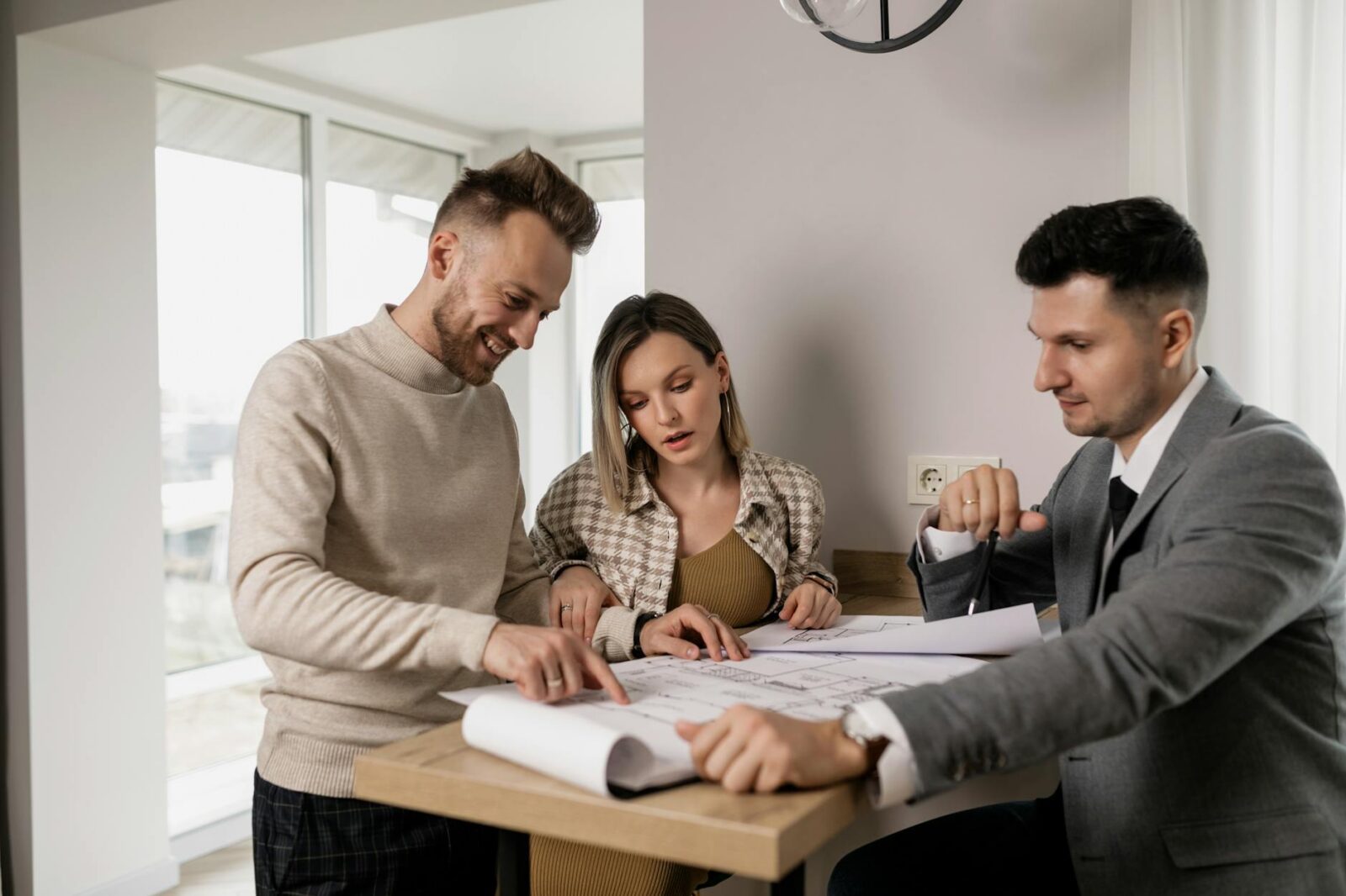 man and woman standing near brown wooden table Home Selling Mistakes That Cost You—And How to Avoid Them