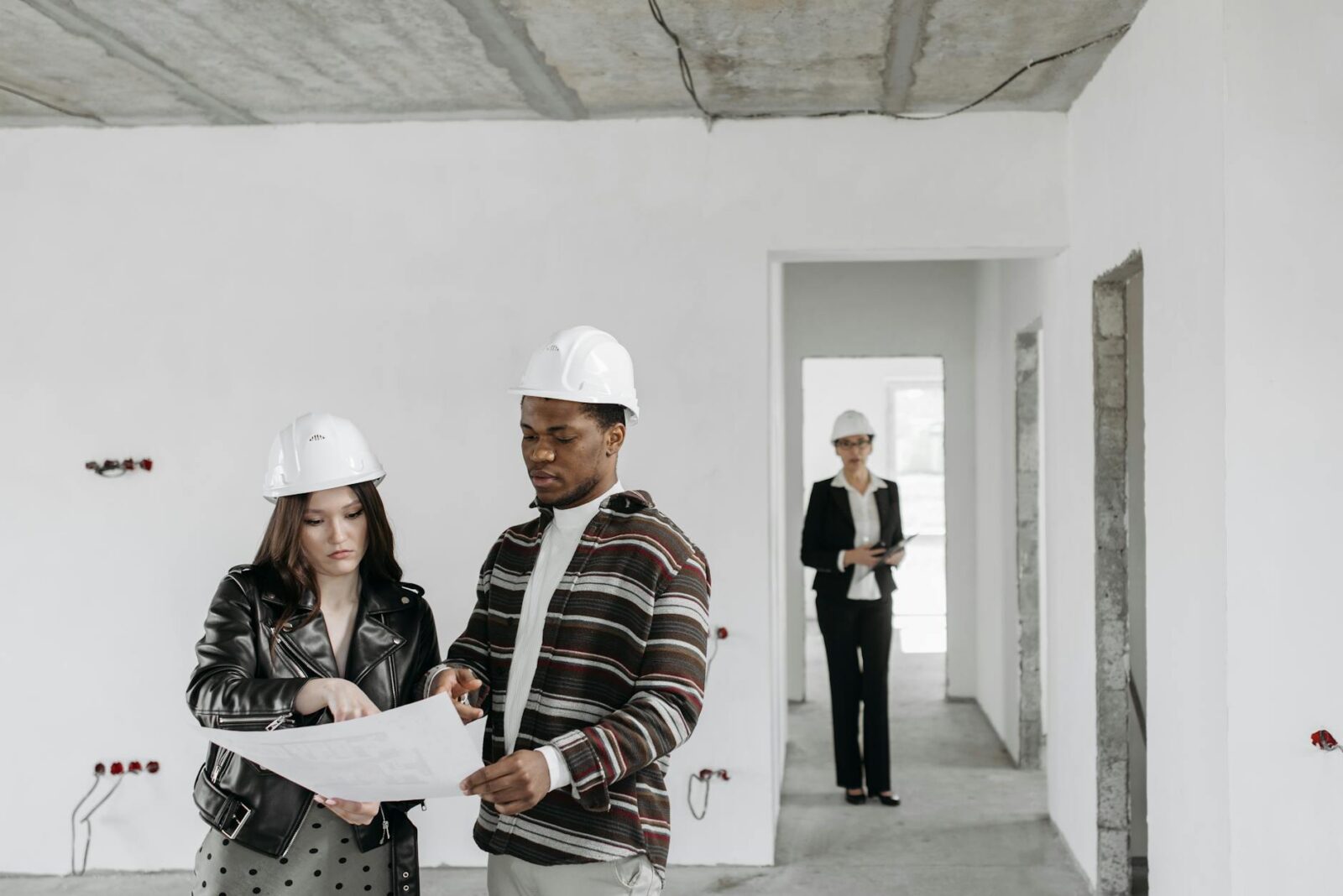 a couple looking at the blue print Top Commercial Real Estate Investment Strategies: Upgrades That Maximize ROI