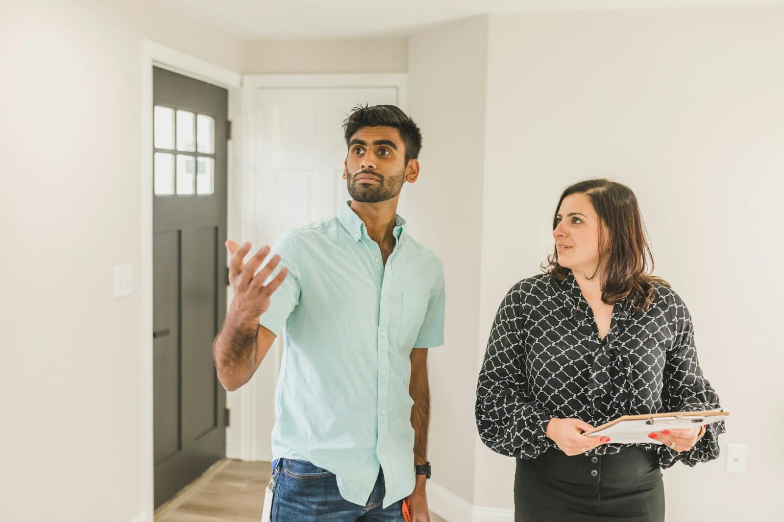 a woman standing next to a man busy looking at the interior of the house Home Selling Mistakes That Cost You—And How to Avoid Them
