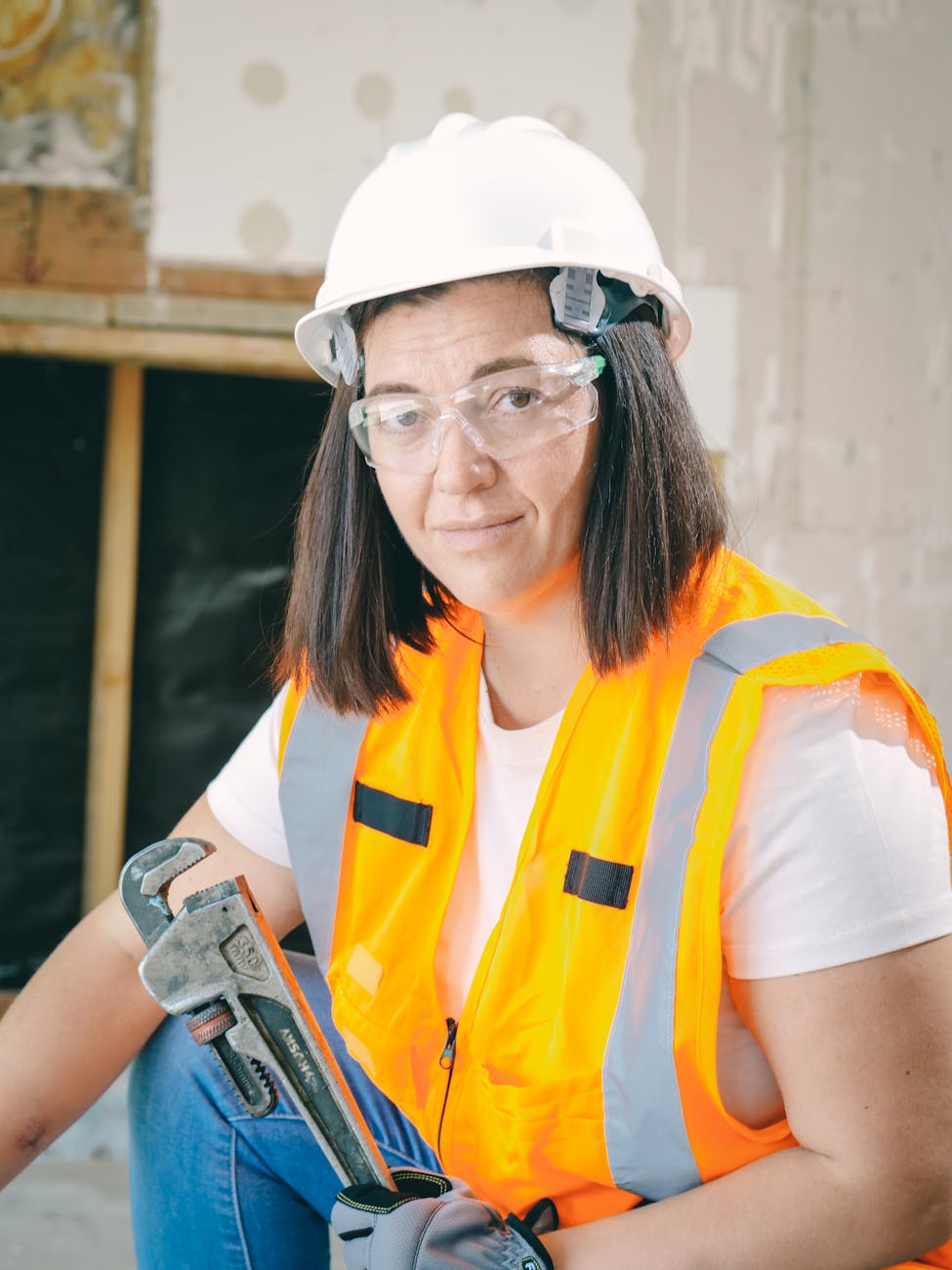 handywoman holding a plumbers wrench Home Fixes You'll Want To Hire A Pro For