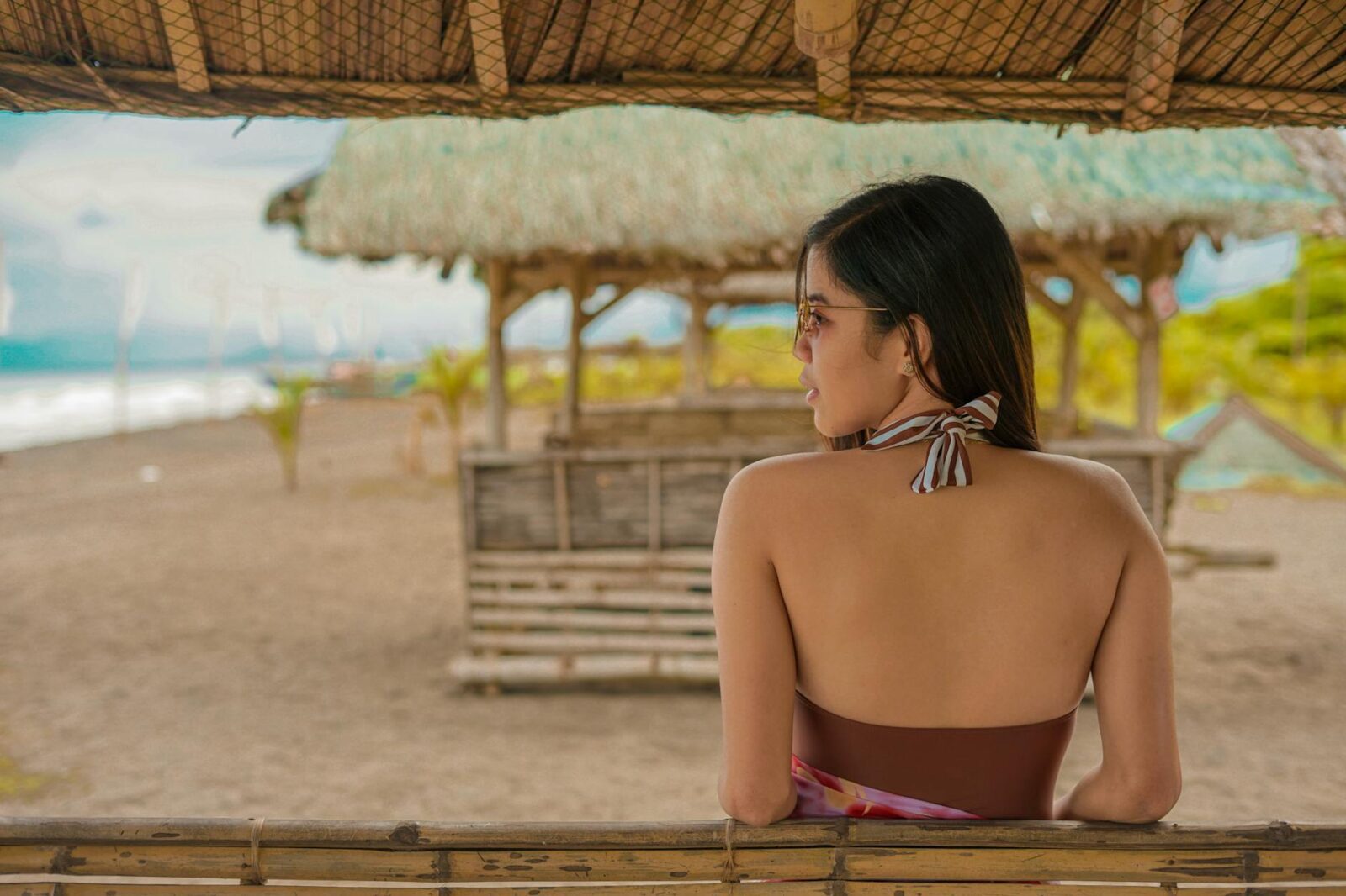 relaxed ethnic woman chilling on beach and admiring ocean view Luxurious Travel Activities to Add to Your Bucket List