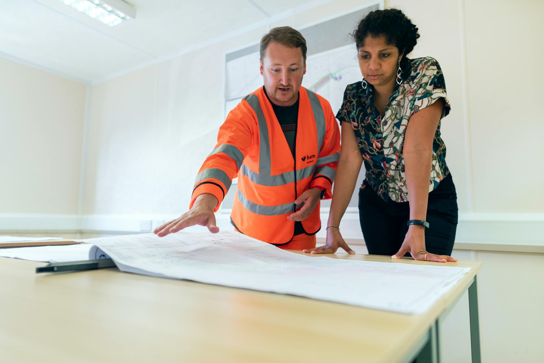 engineers looking at blueprint How to Survive Renovating Your Home (Without Losing Your Mind as a Working Mom)