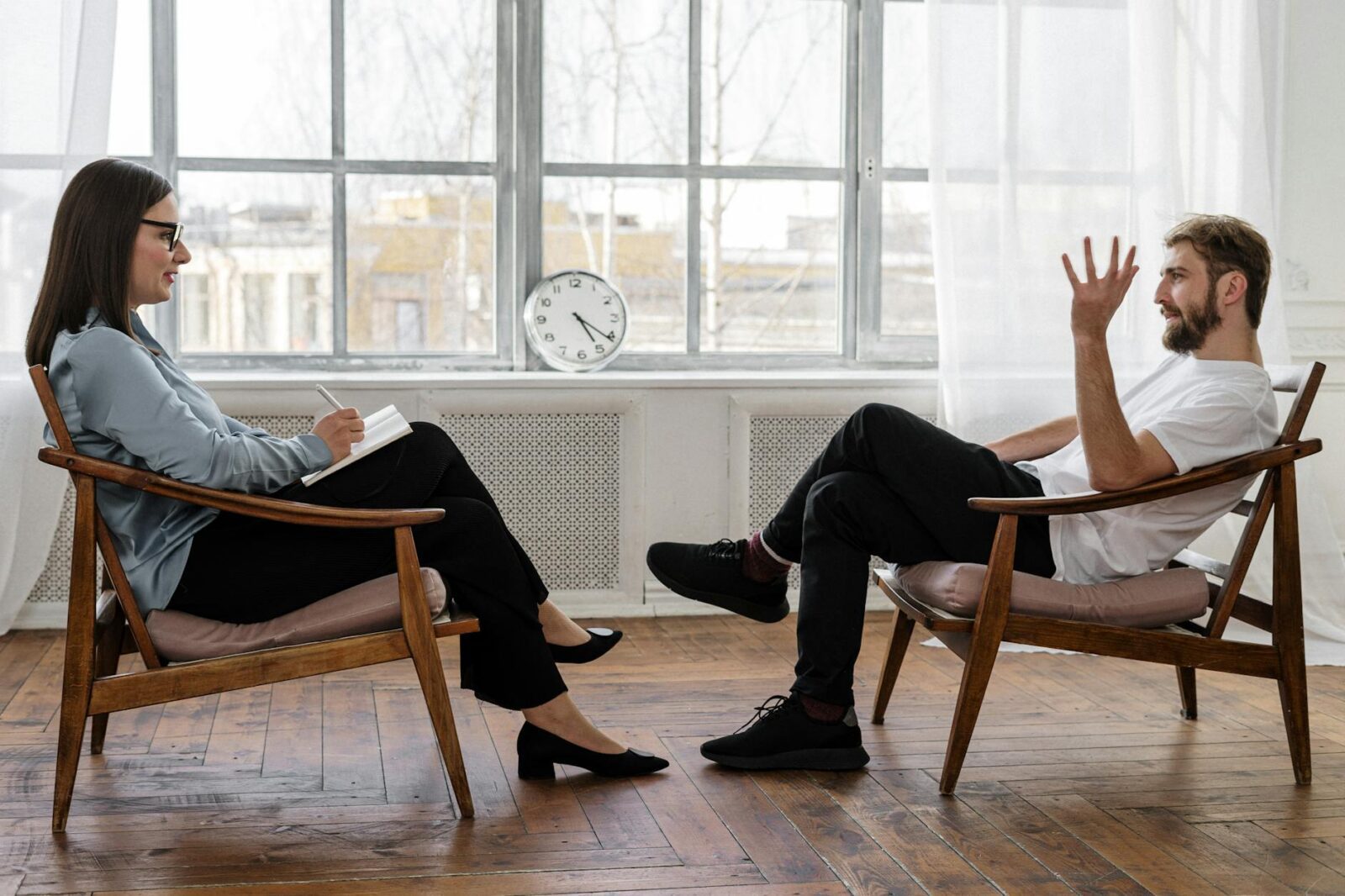 person in black pants and black shoes sitting on brown wooden chair Wellness Careers For People Who Love Health
