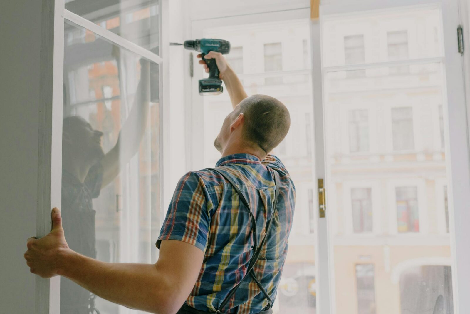 handyman installing window frame with drill in house 6 Ways Preventative Maintenance Saves Your Business Money