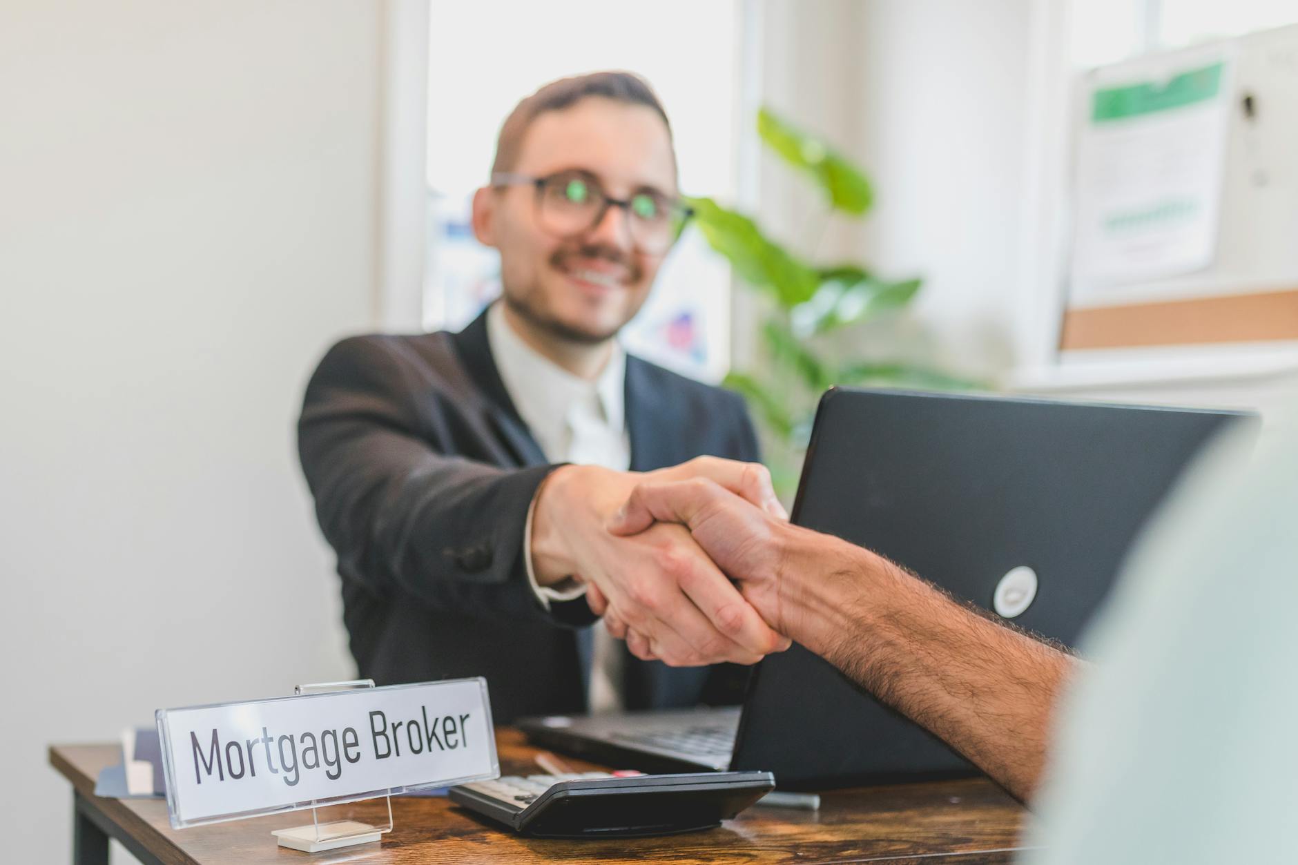 a broker shaking having a deal with the person sitting in front of him 7 Tips for First-Time Home Buyers: How to Make Your Dream Home a Reality