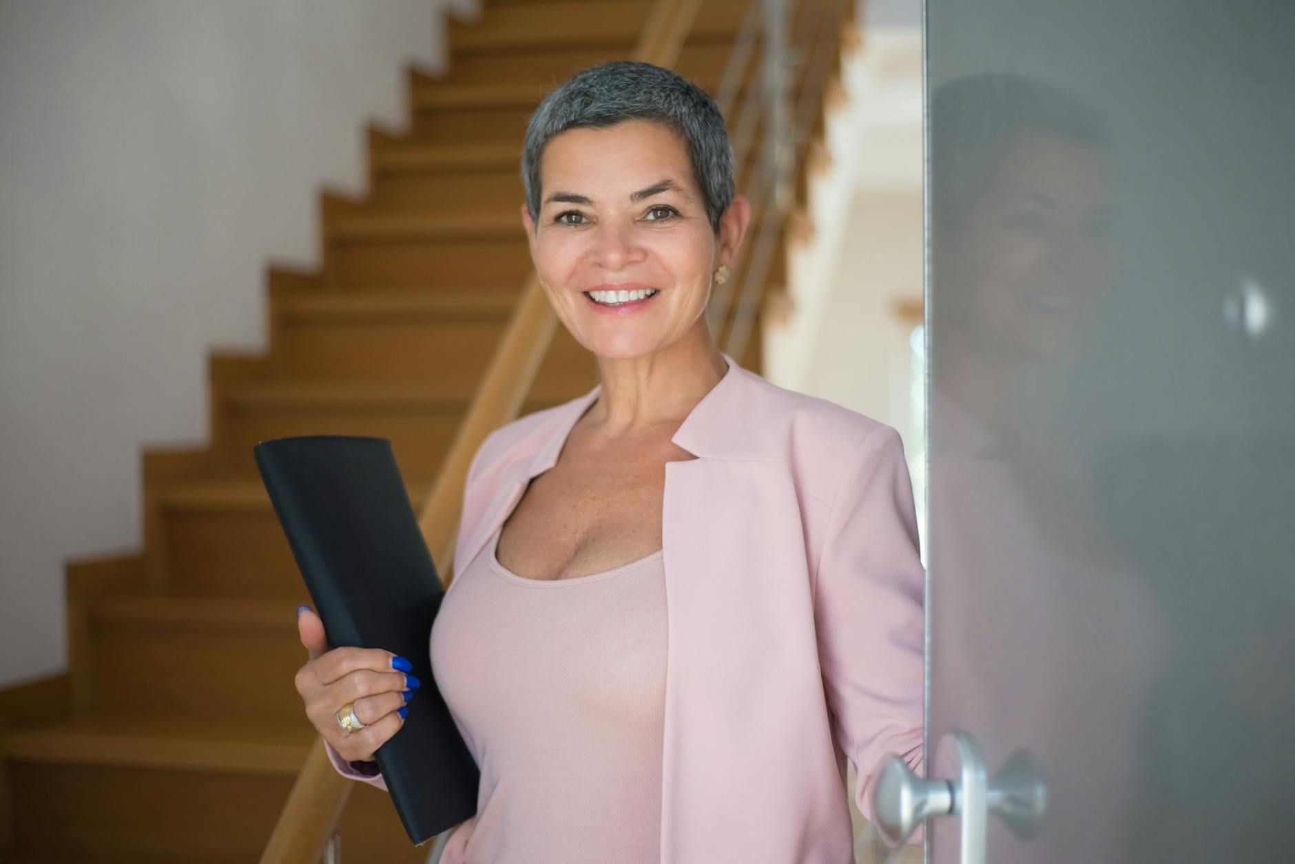 an elderly woman holding a folder while standing on the doorway Rethinking Your Career Path? How to Start Working in Real Estate