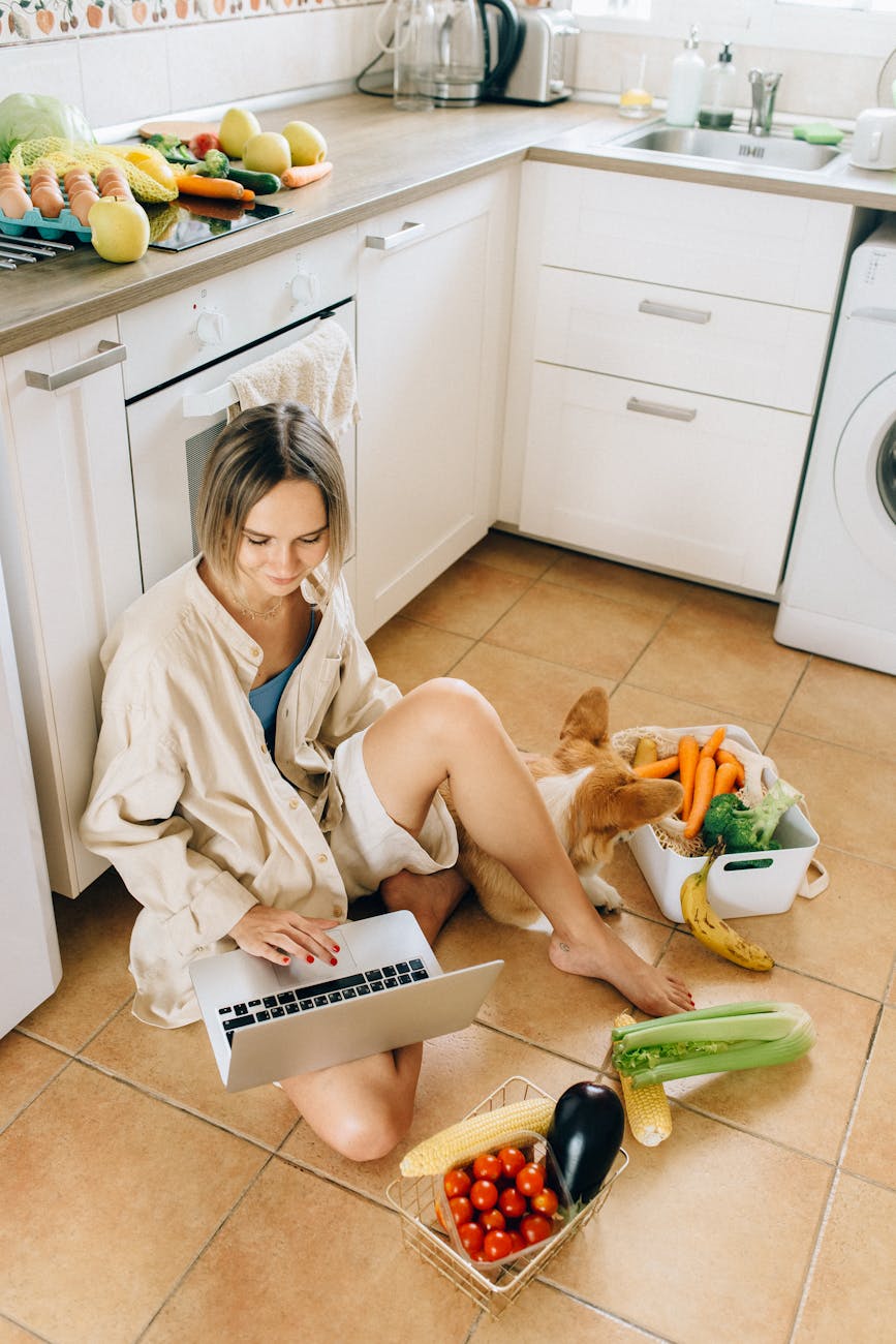 woman sitting on the floor while using a laptop Shaving Dollars From Your Grocery Bills: Shopping Tips to Save Money