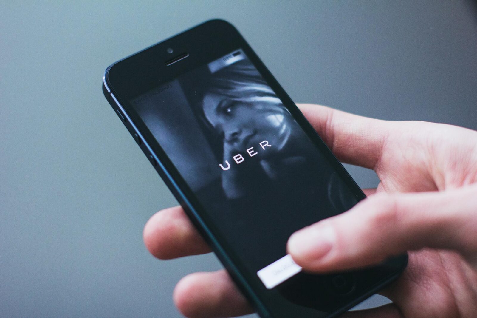 person holding smartphone The Pros and Cons of Rideshare Services