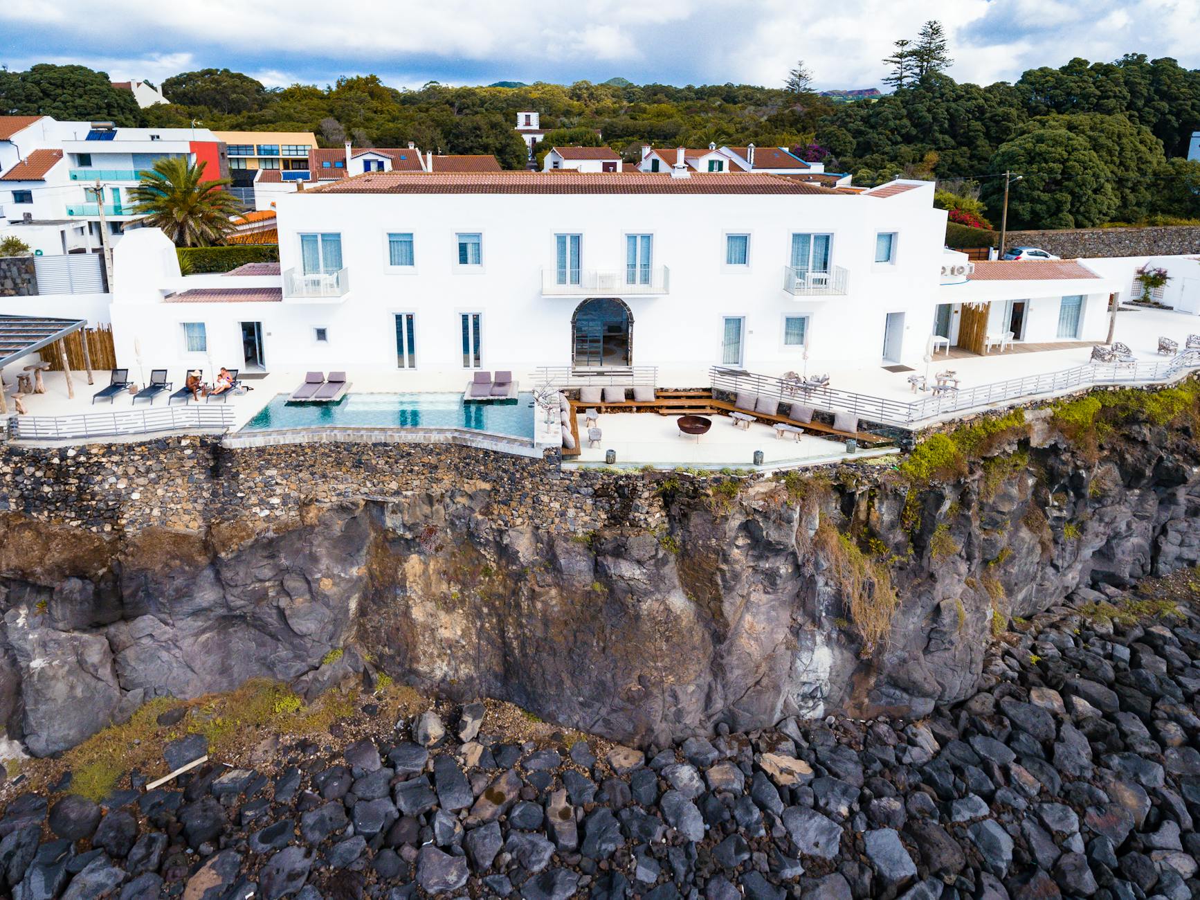 white and brown concrete building on a cliff What Makes a Market “Elite”: High-End Vacation Rental Investment Hubs