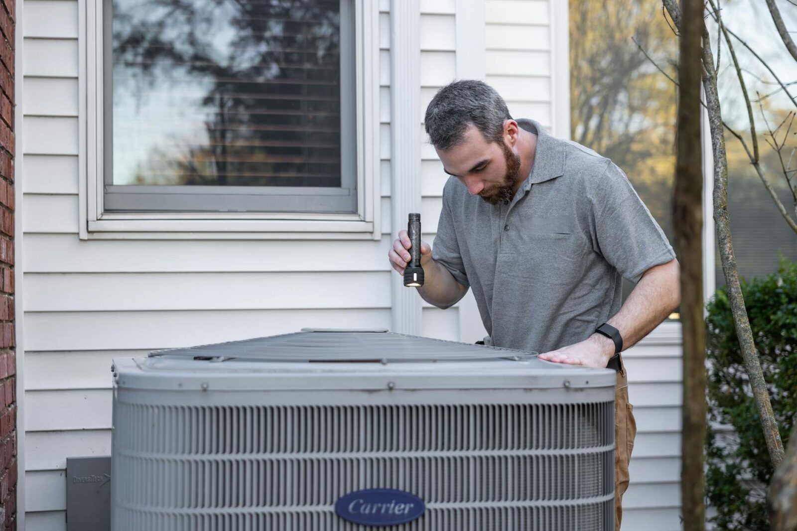 technician inspecting outdoor hvac unit How You Can Seamlessly Prep Your Home for Seasonal Changes