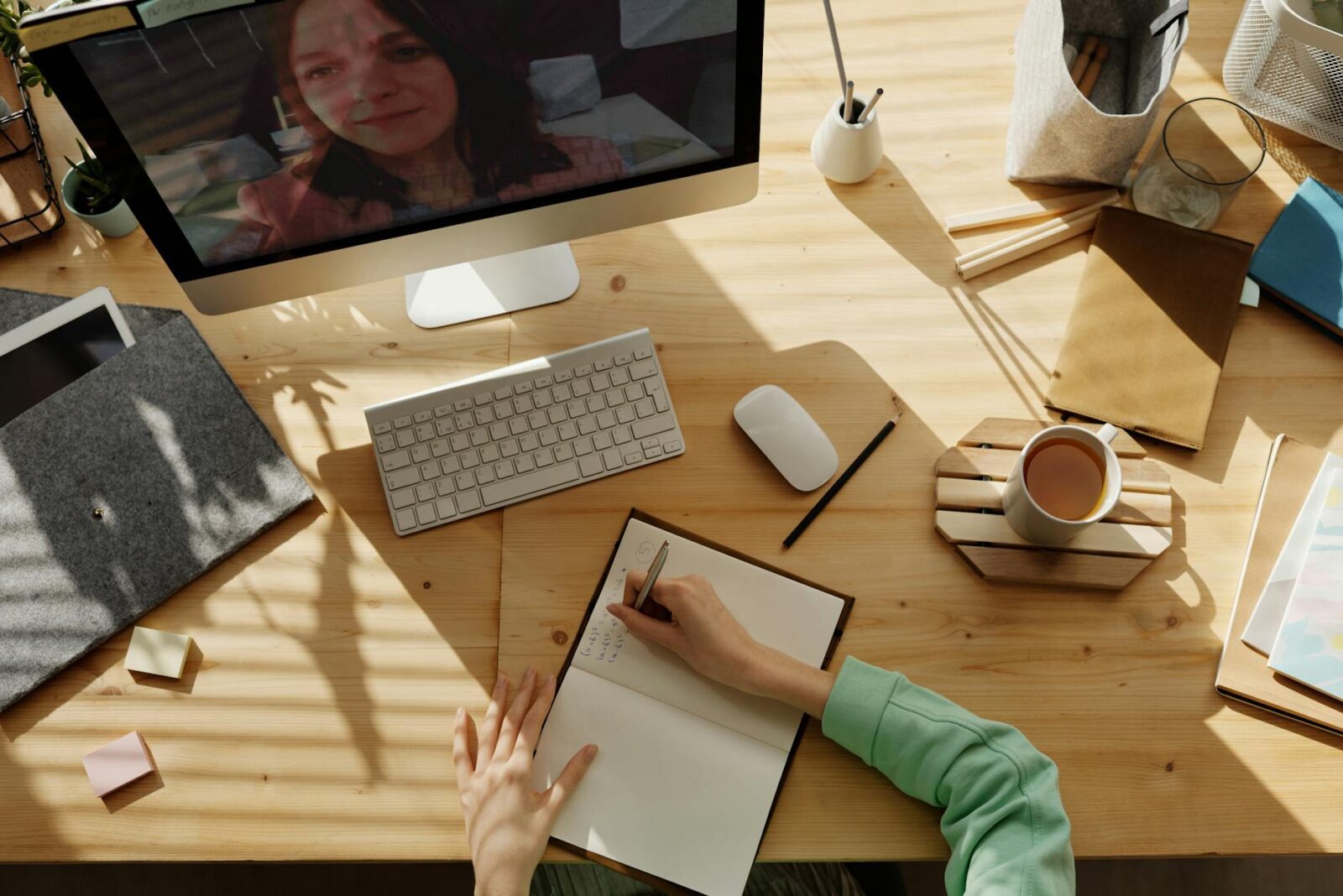 person writing on notebook Why Virtual Meetings Are a Game-Changer for Real Estate Efficiency