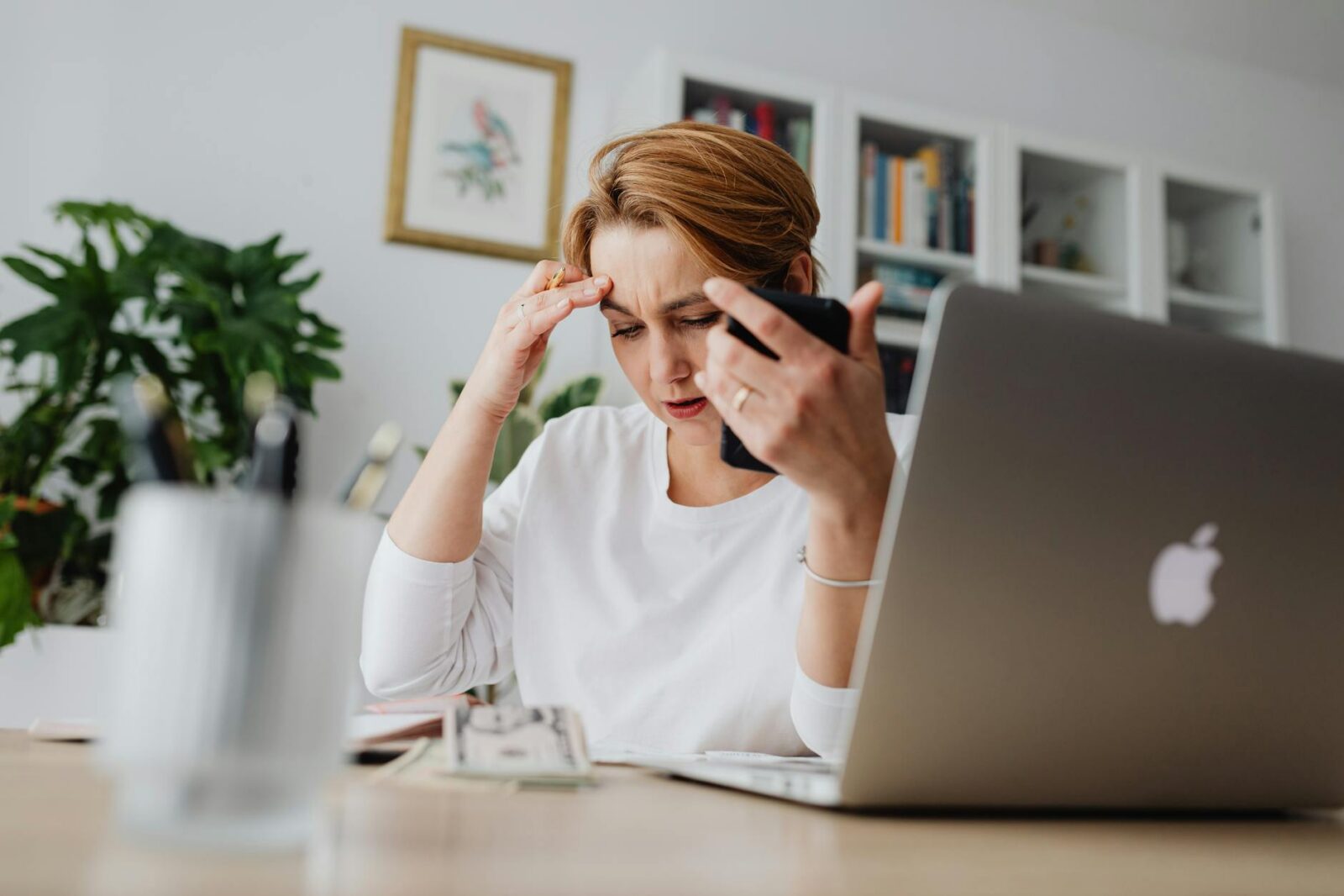 woman sitting at the desk with the laptop Overwhelmed By Debt? Here's How to Get Through It