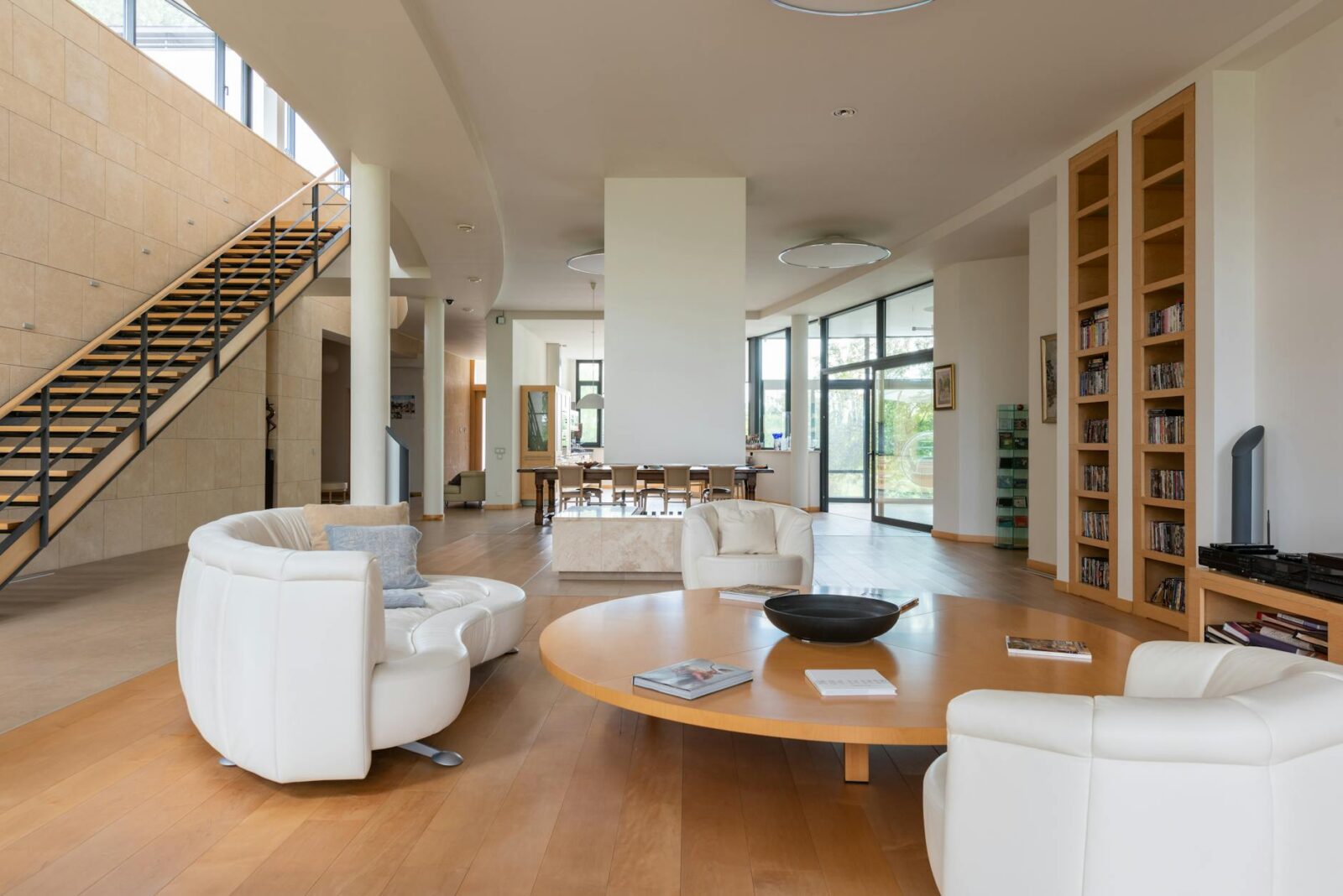 spacious apartment with bookshelves and round shaped wooden table The Biggest Renovation Mistakes People Are Still Making in 2025