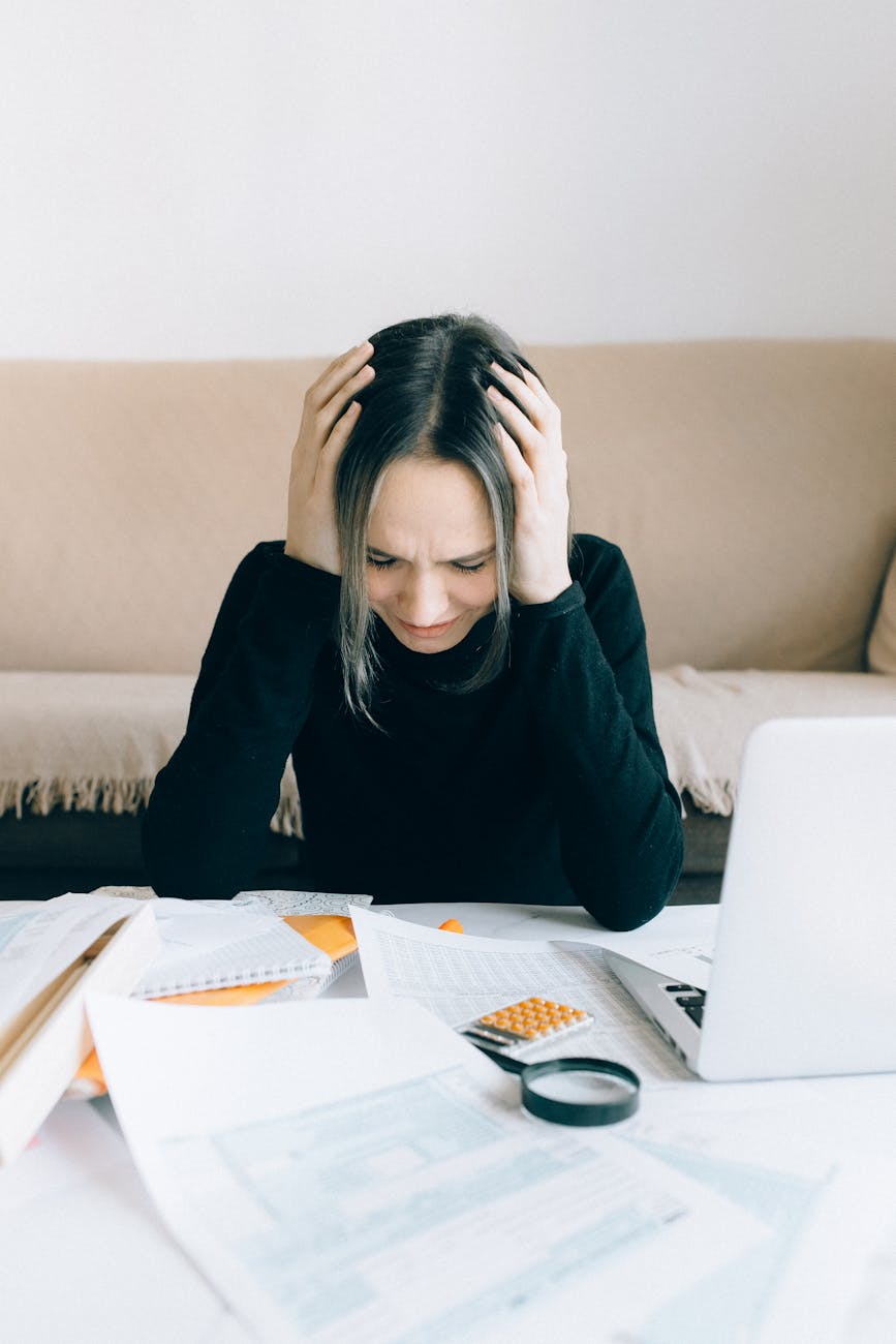 exhausted woman holding her head 7 Foolproof Strategies to Tackle Your Financial Stress