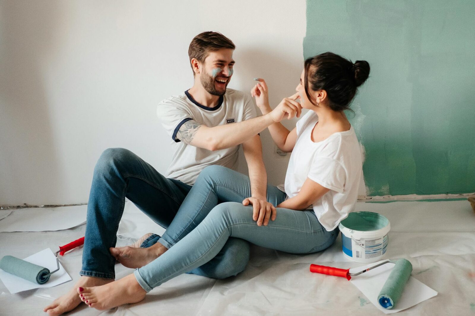 happy couple sitting on the floor with paint on their faces