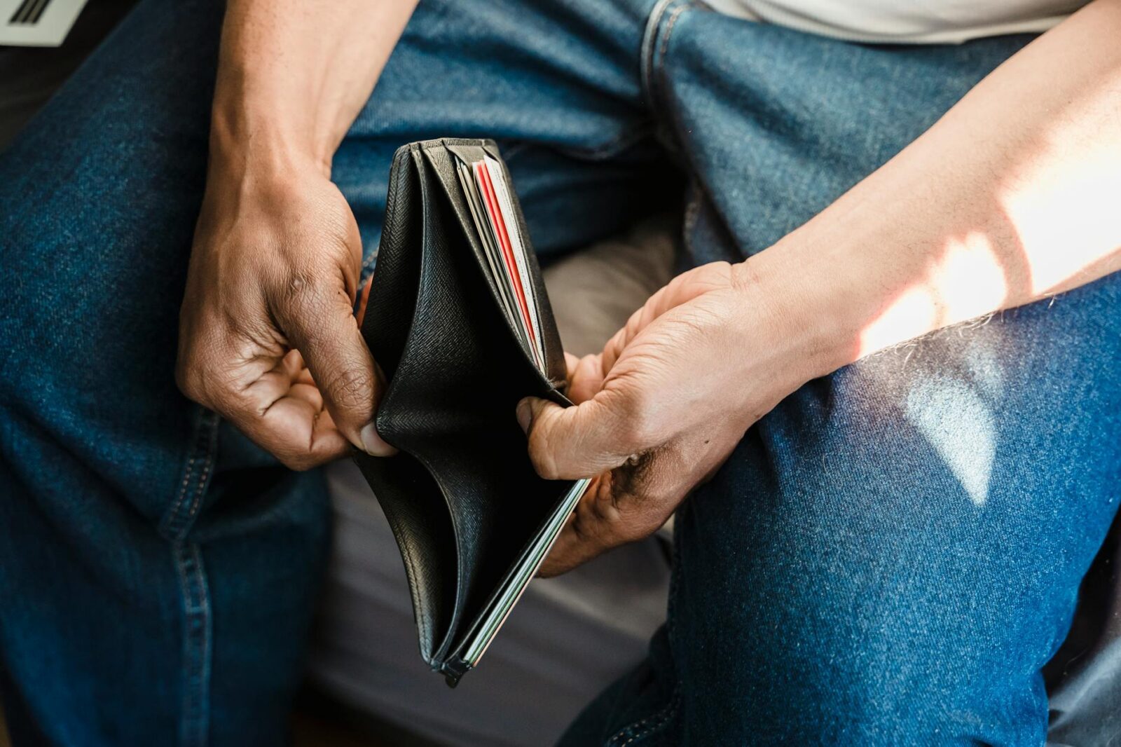 man looking at an empty wallet Overwhelmed By Debt? Here's How to Get Through It