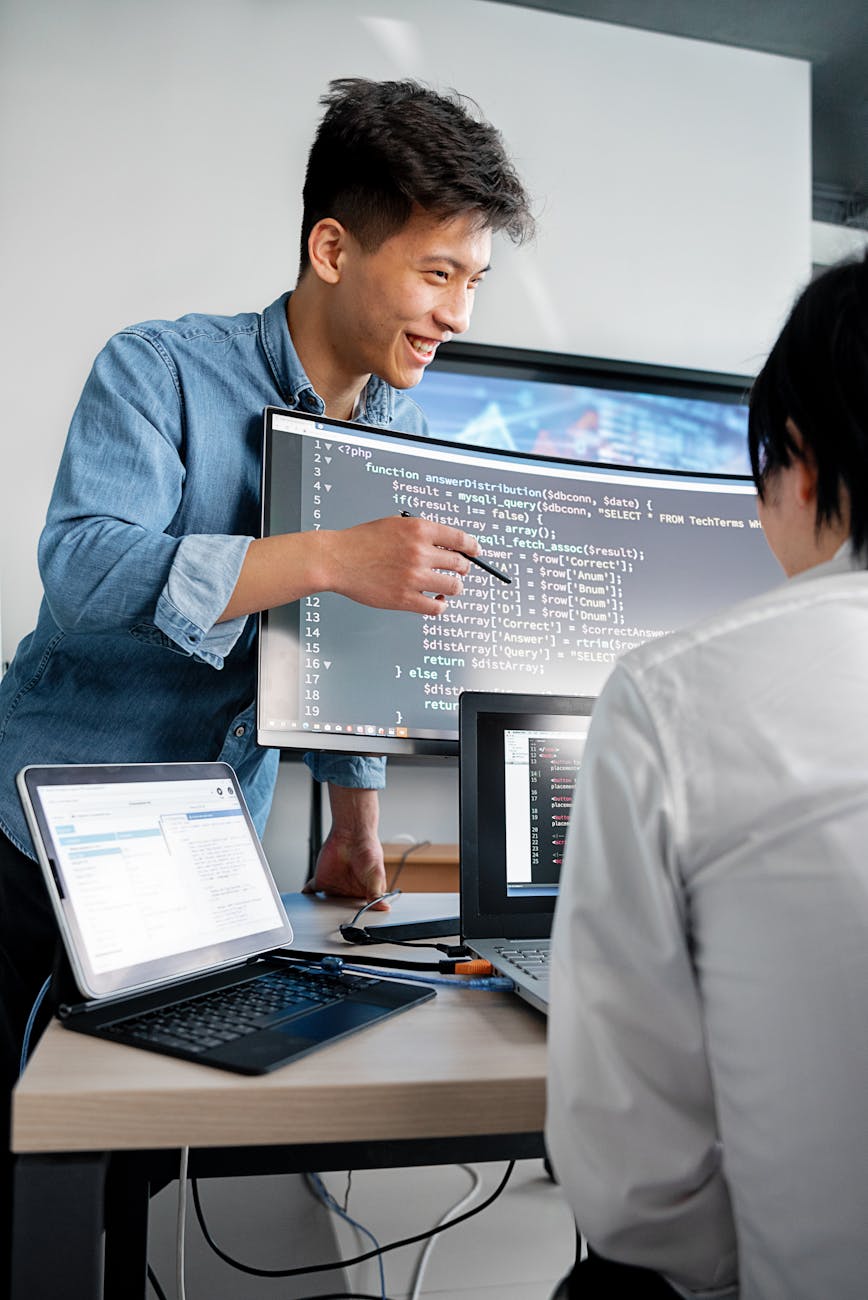 a man in gray denim long sleeves pointing the codes on the monitor 3 Essential Tips to Run a Successful Business & Make a Profit