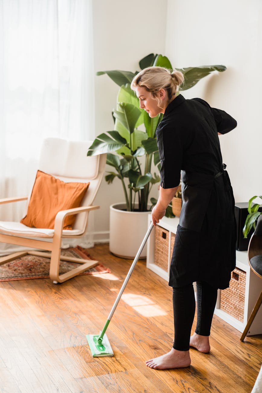 a woman sweeping a floor How You Can Seamlessly Prep Your Home for Seasonal Changes