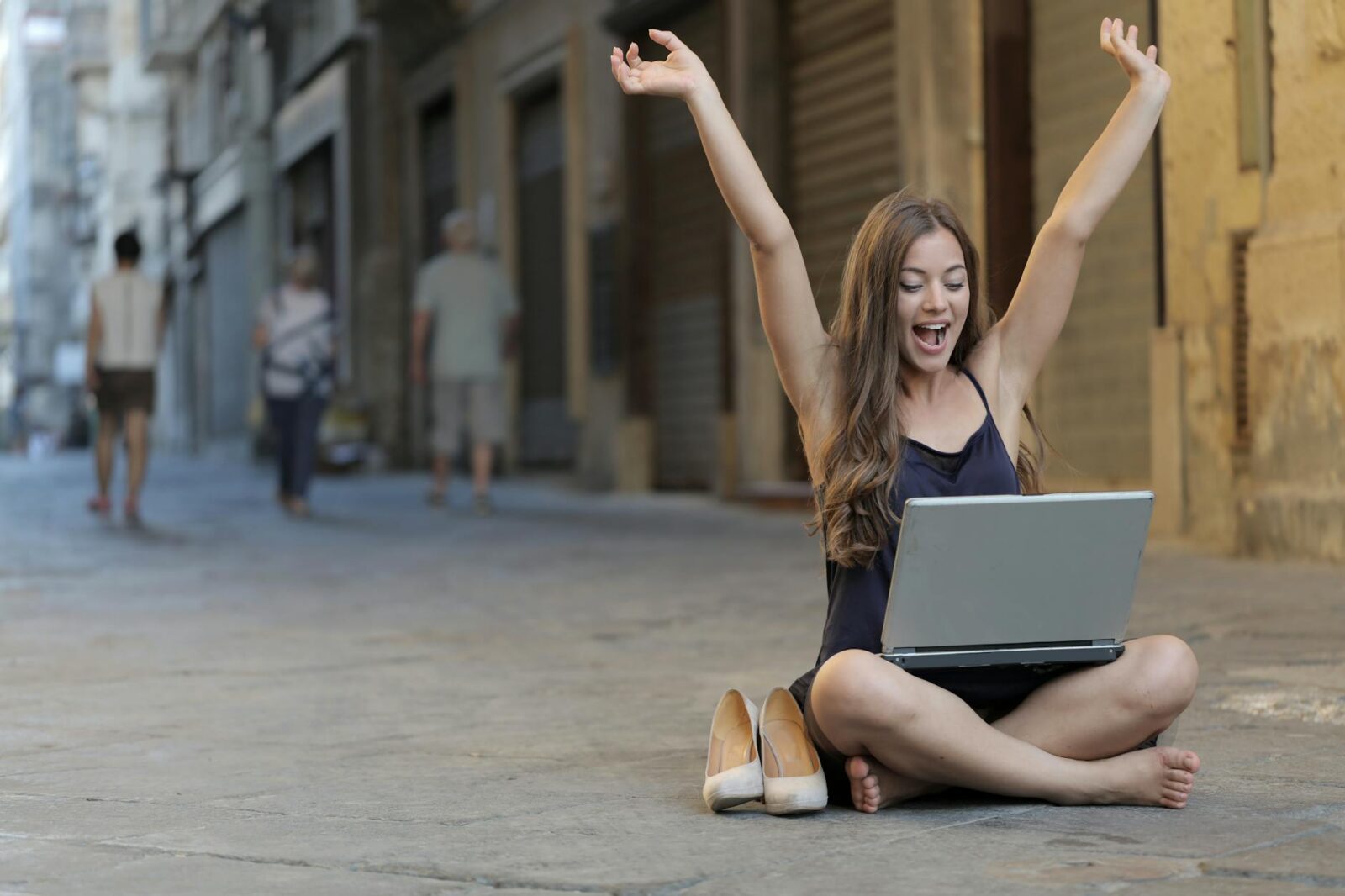woman raising her hands up while sitting on floor with macbook pro on lap Planning a Career Change: Key Steps for a Smooth Transition