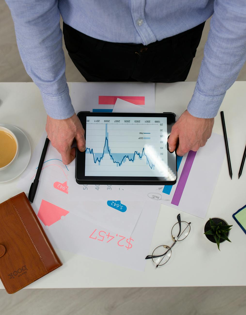a person holding an ipad on the table Are You Struggling With Your Business? How to Fix It and Grow Stronger