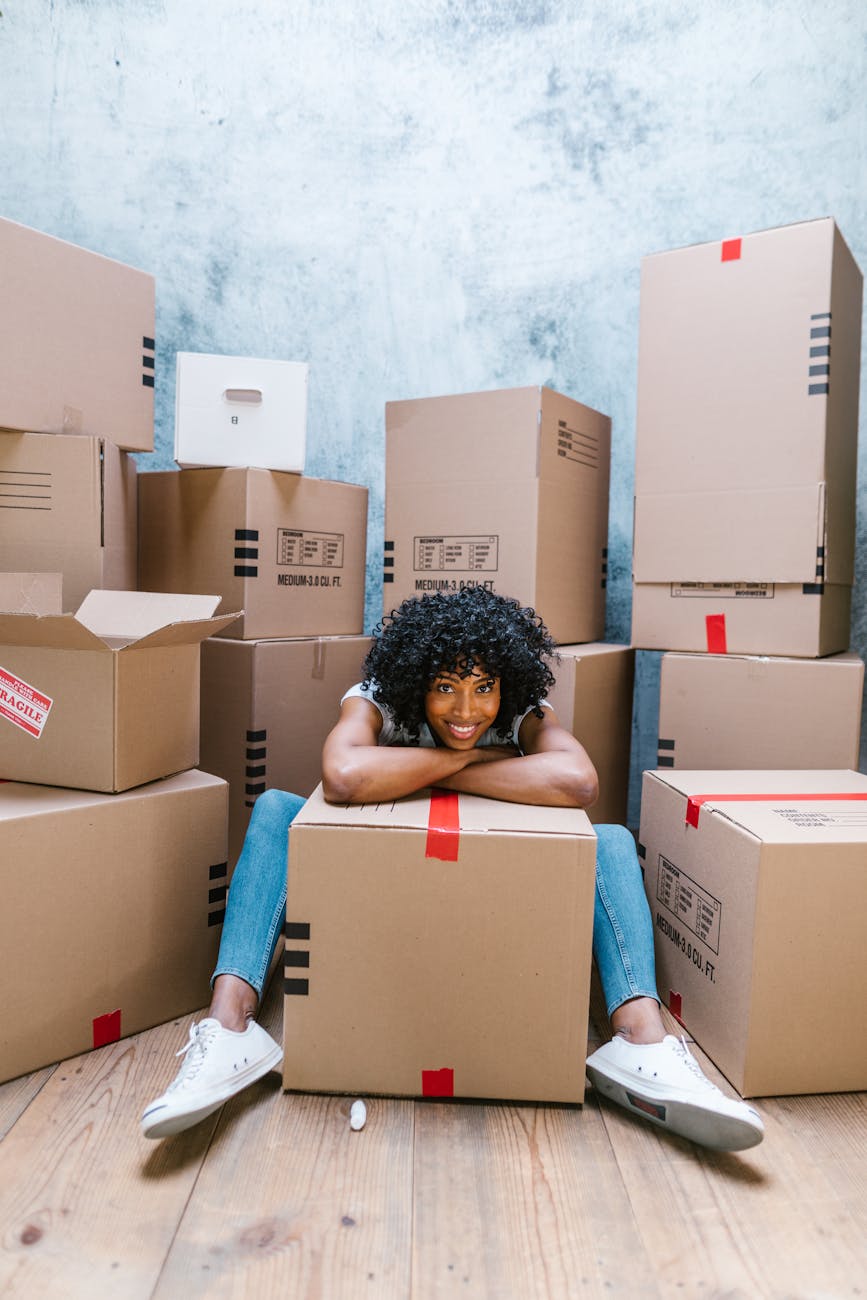woman in blue denim jeans sitting on brown cardboard boxes Planning a Career Change: Key Steps for a Smooth Transition