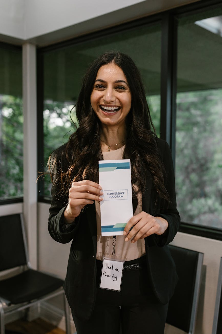 a woman holding a brochure while standing near the glass windows 5 Essential Strategies to Build Brand Visibility Long-Term