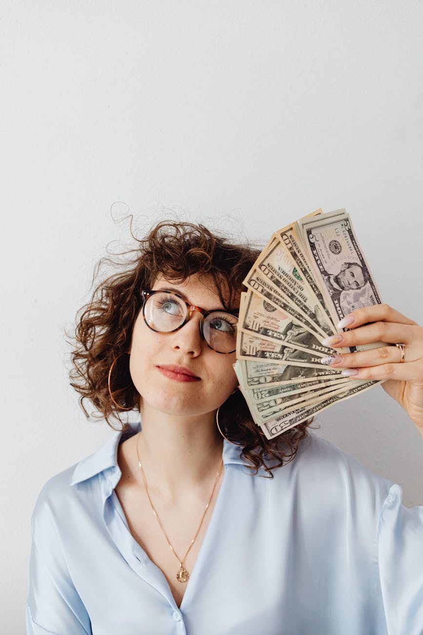 curly haired woman holding paper money Planning a Career Change: Key Steps for a Smooth Transition
