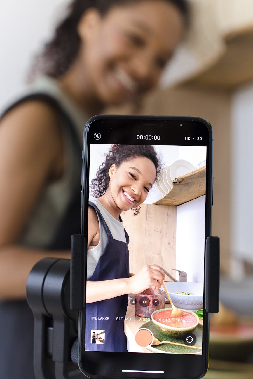 a screen of a smartphone woman smiling while cooking The Low Down on Launching a Profitable Blog