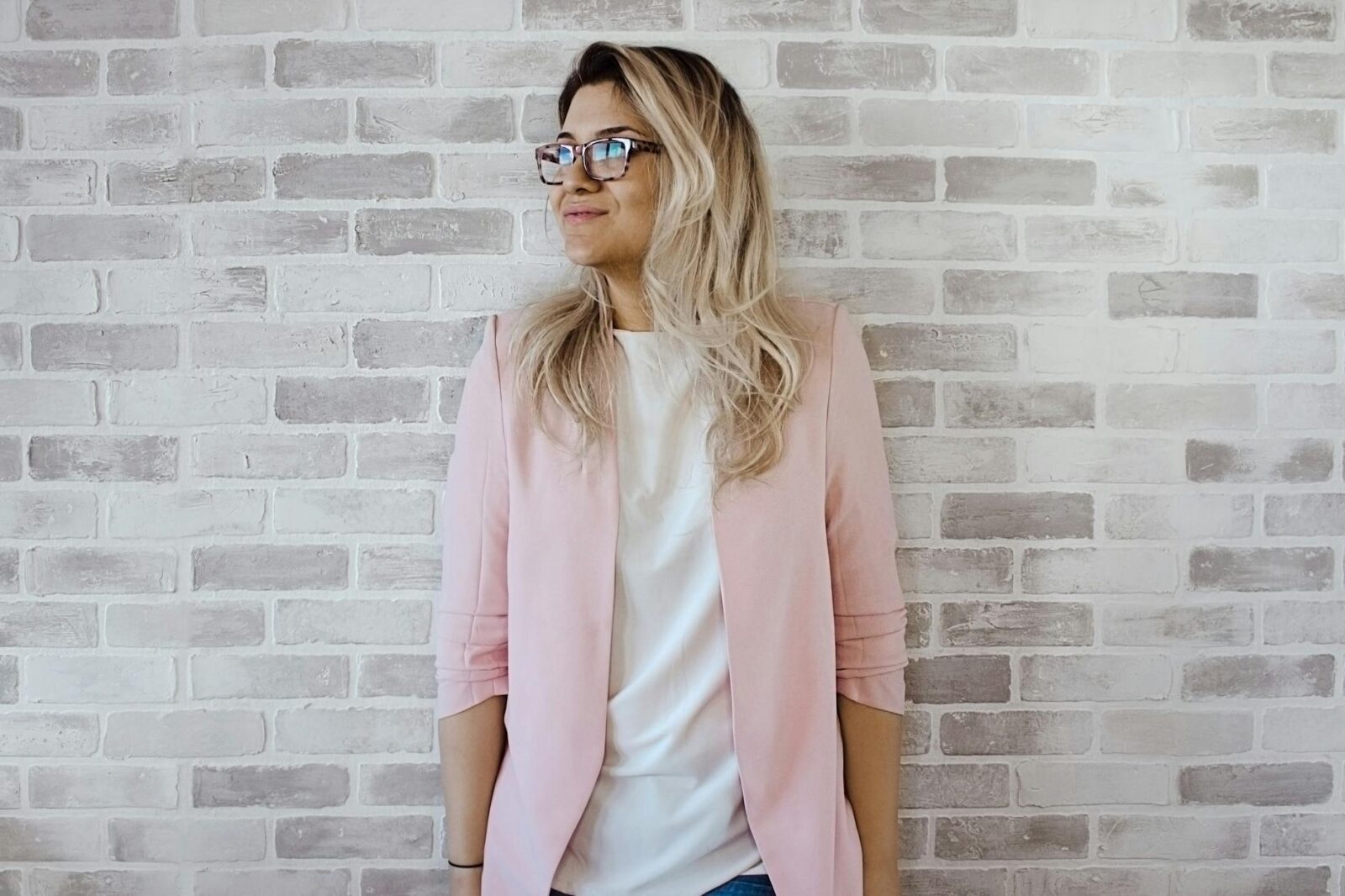 woman in pink cardigan and white shirt leaning on the wall Planning a Career Change: Key Steps for a Smooth Transition