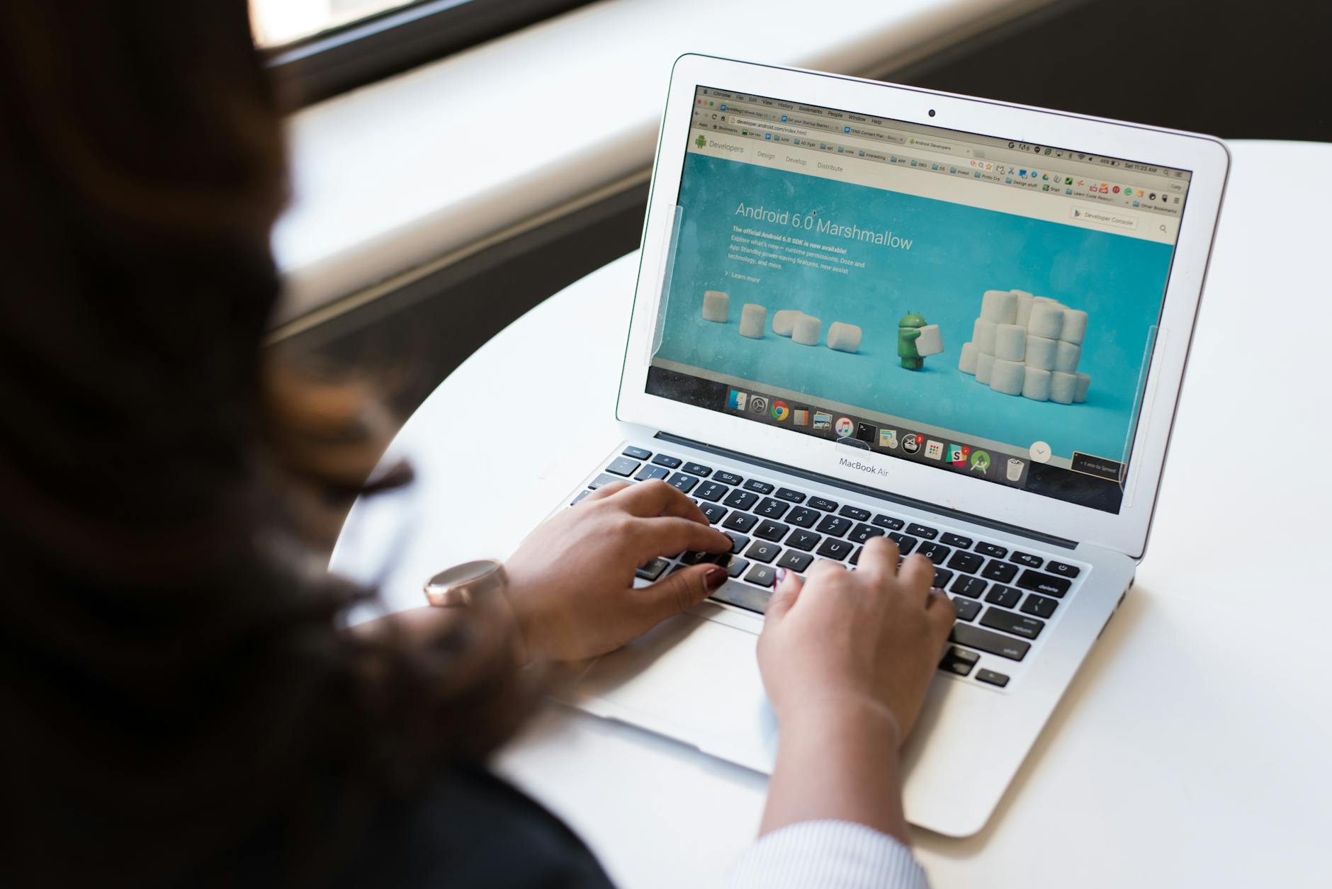 woman sitting near table using macbook How to Make Your Small Business Stand Out In a Crowded Marketplace