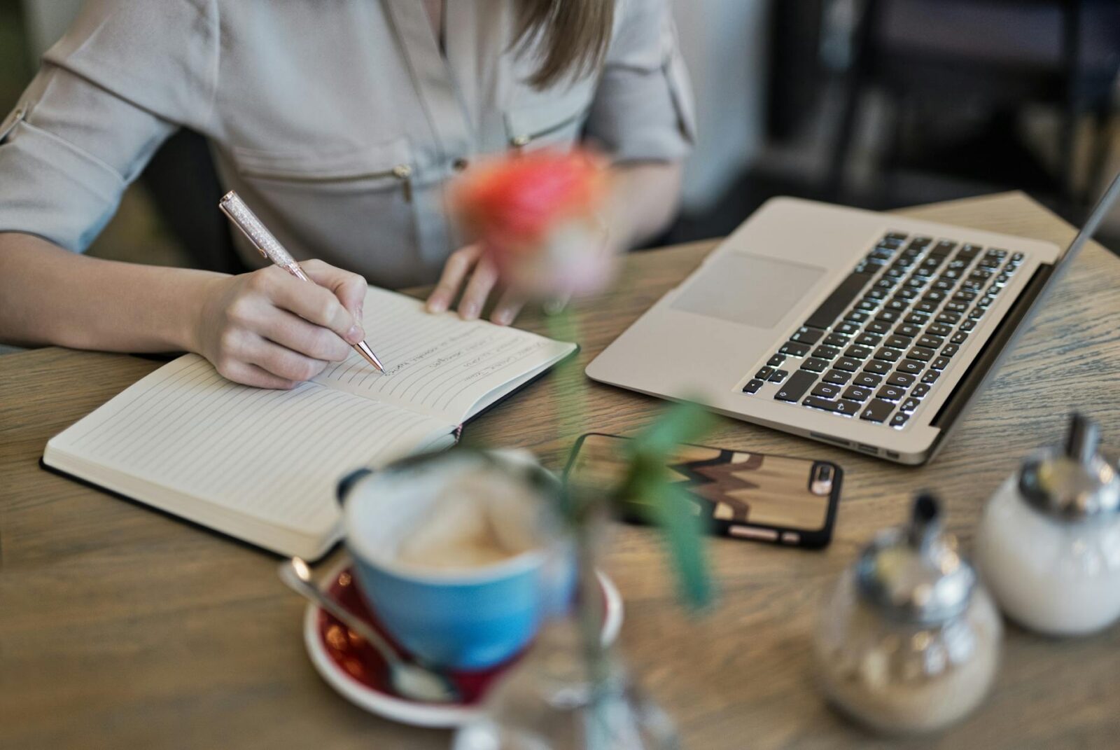 person writing on a notebook beside macbook Sabbatical Planning Tips: How to Relax, Travel, and Find New Purpose
