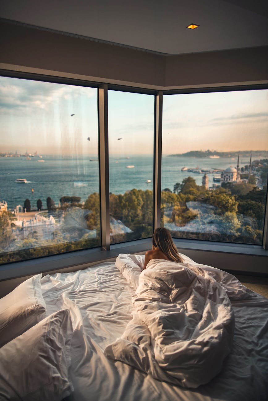 woman laying down on bed inside room Elevate Your Escape: Plan a Luxury Travel Experience