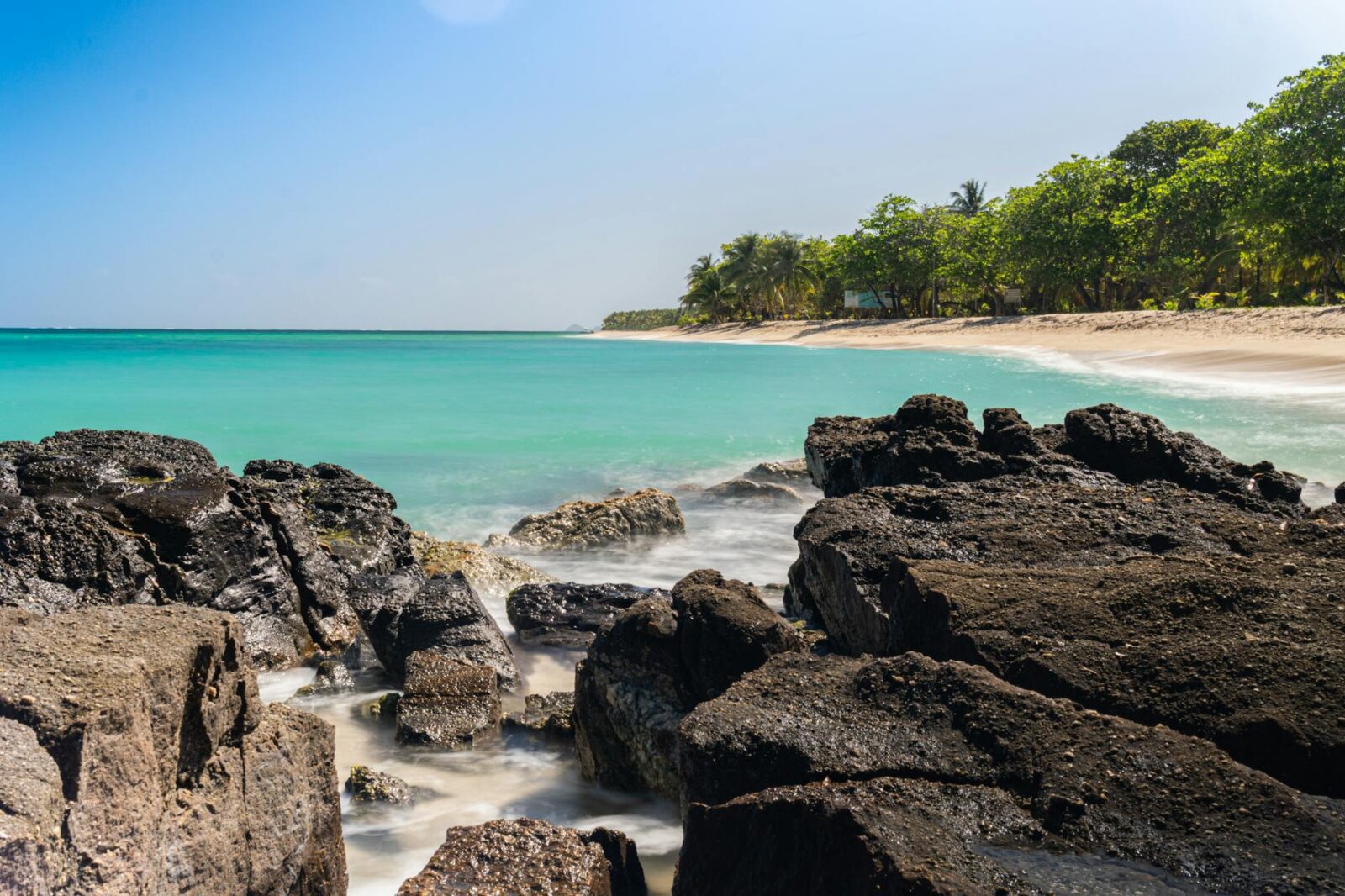 beach with blue water and a rocky shore Why Honduras Property Investment Is a Smart Choice for Your Real Estate Portfolio