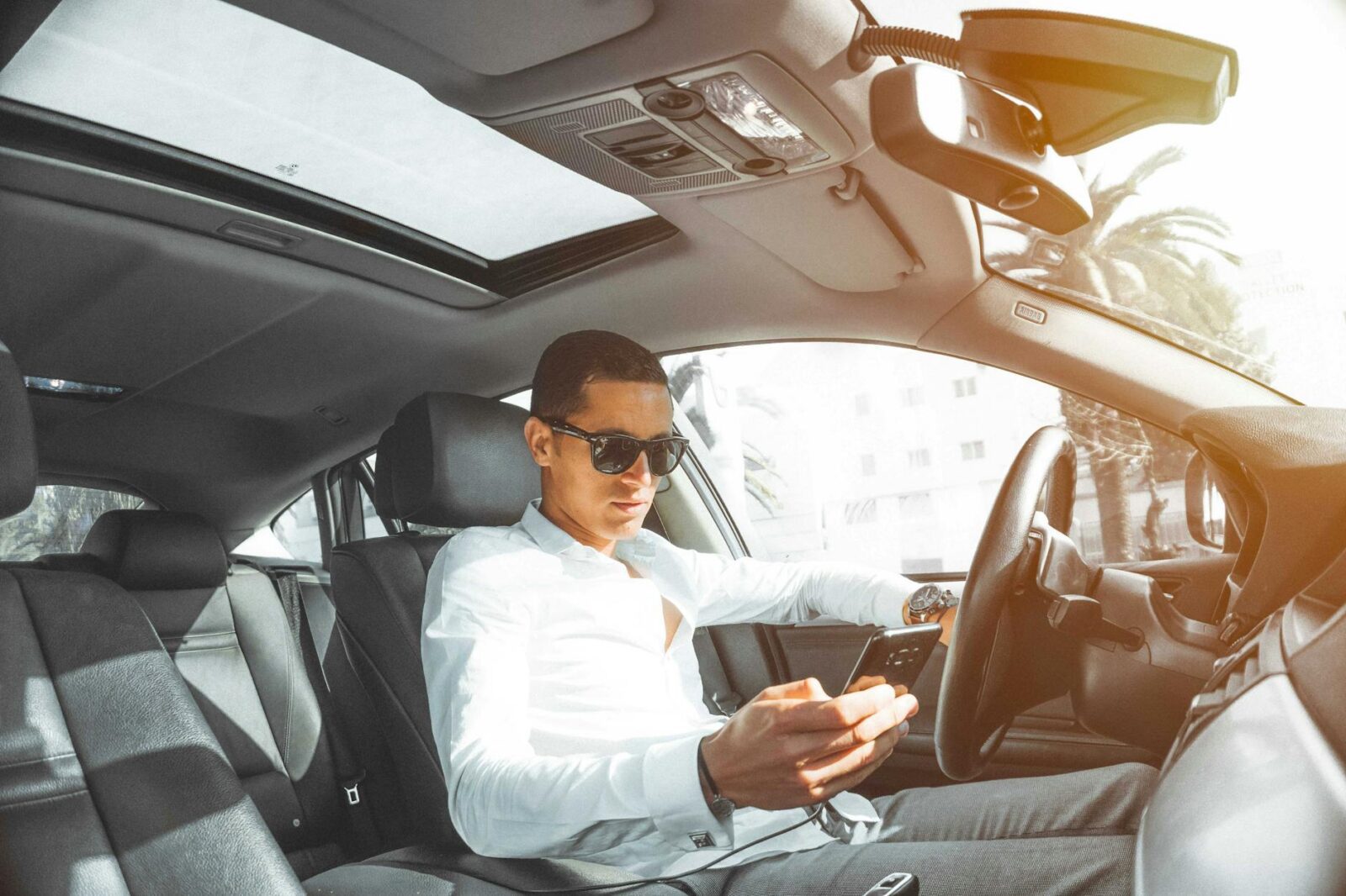 man in white dress shirt holding smartphone What to Do After a Car Accident: Step-by-Step Checklist