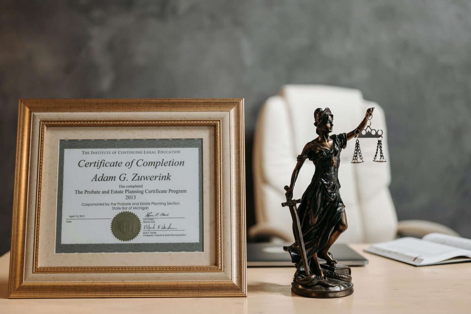 a certificate and lady justice figurine on table What To Do When Inheriting A Large Sum Of Money