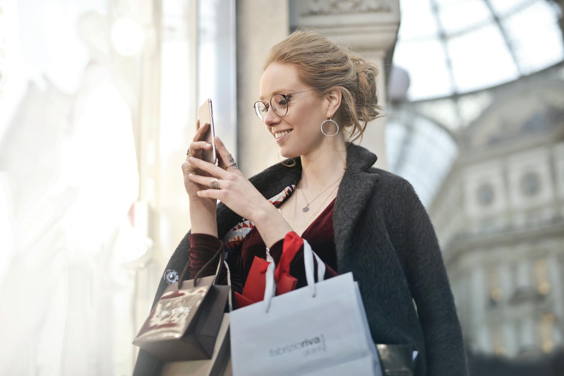 woman standing near wall holding phone 3 Reasons Why FOMO Is The Best Marketing Tactic