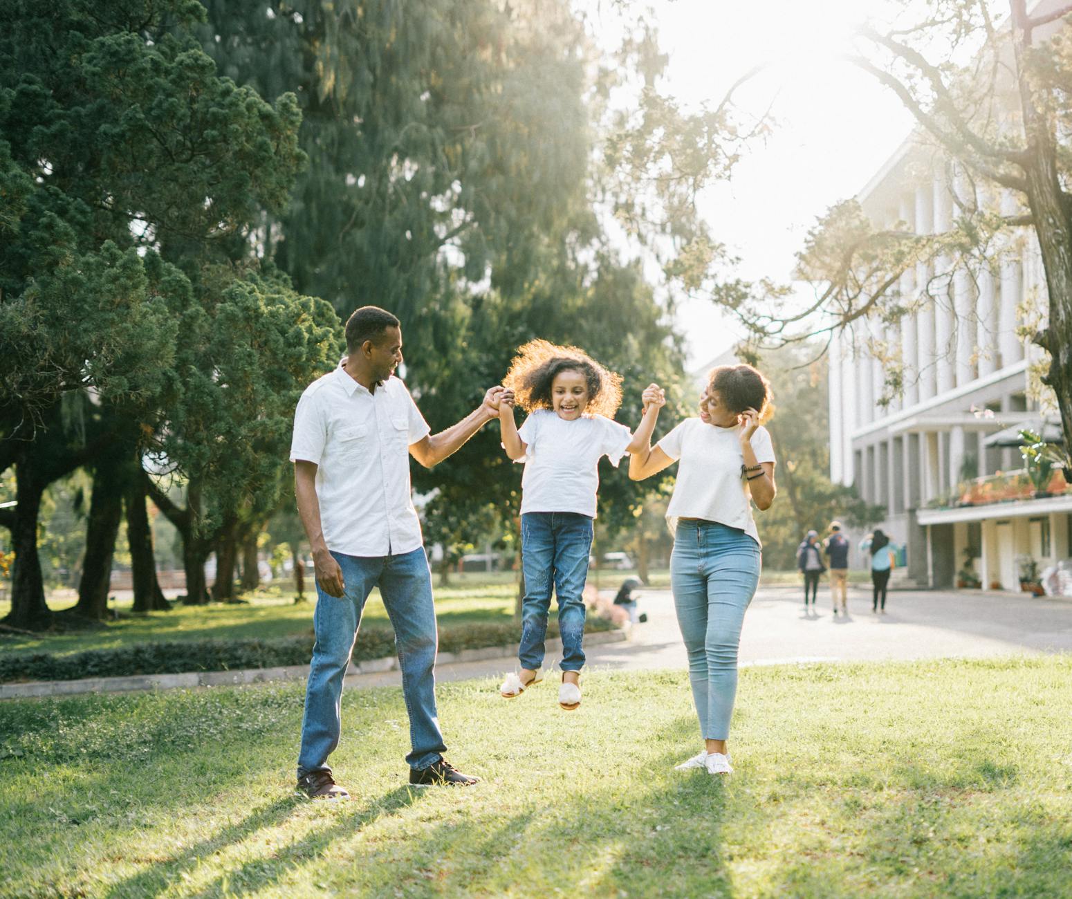 a man and a woman assisting a girl while jumping What to Do When Your Child Is Struggling to Make Friends at School