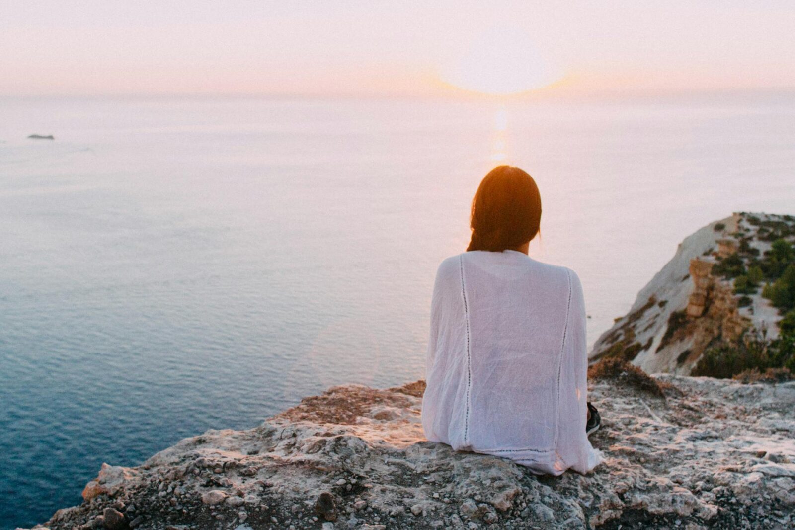 woman sitting on gray rock near body of water Calming Techniques for When Your Thoughts Feel Out of Control