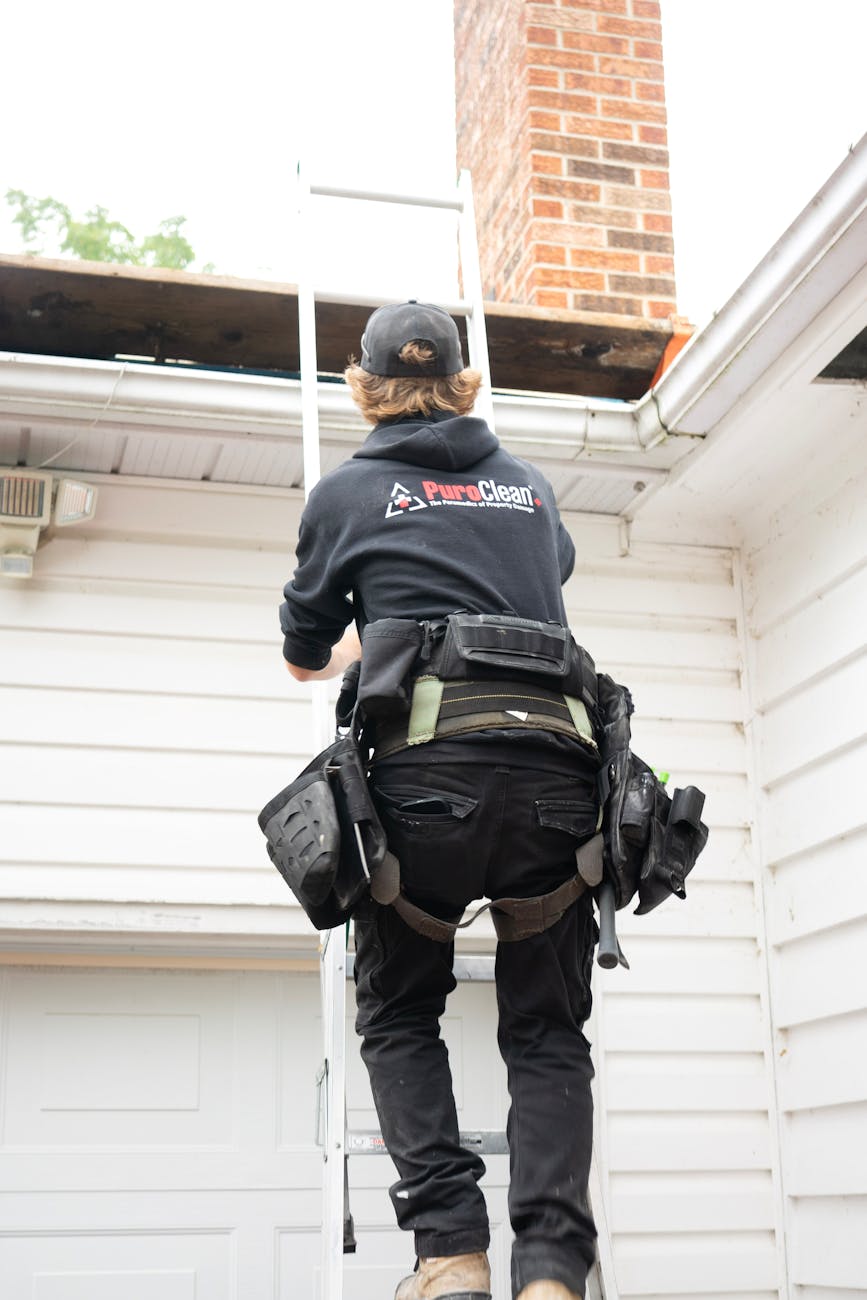 professional roofer climbing ladder near chimney 8 Things You’ll Regret Not Doing Before Moving Into Your New Home
